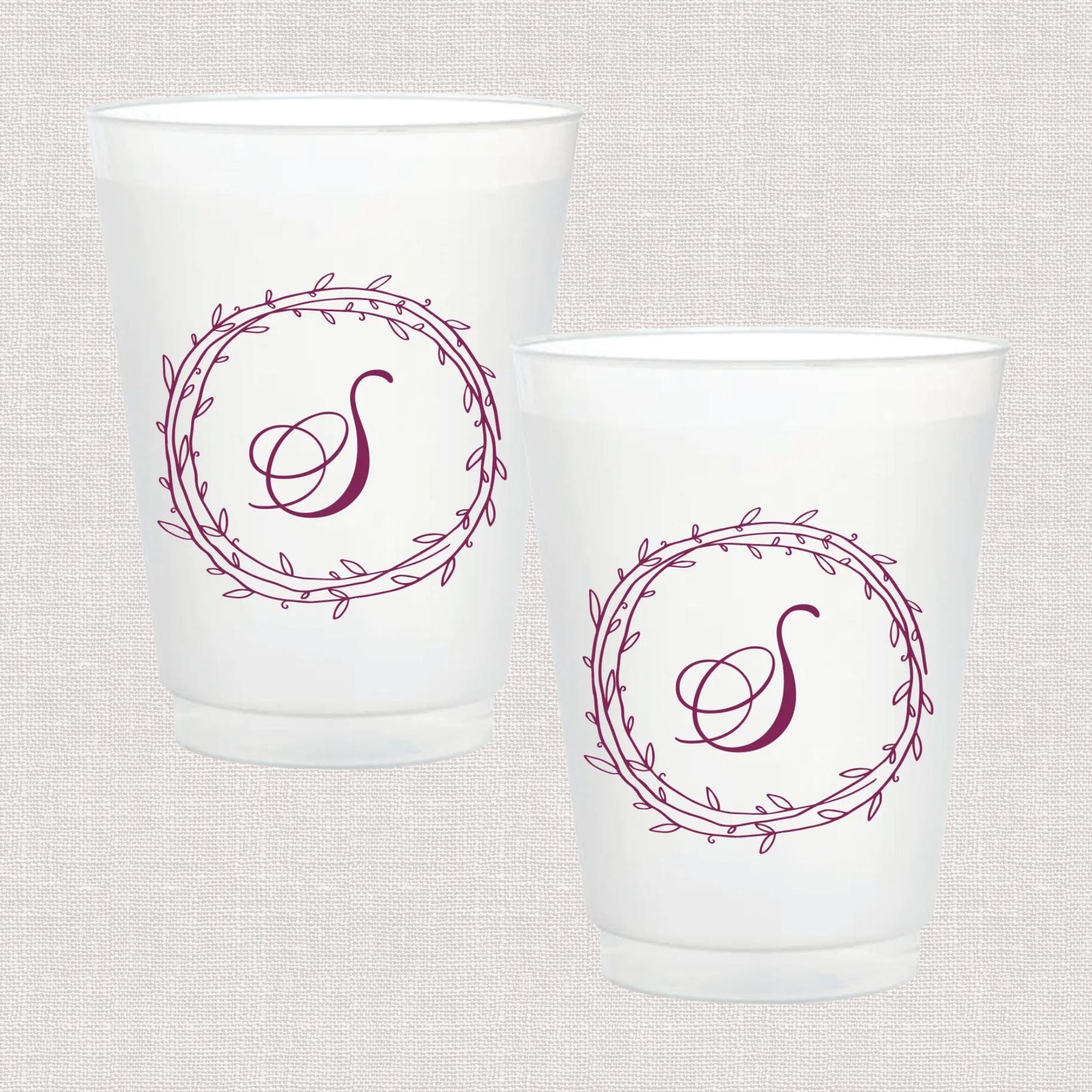Pair of frosted white cups with burgundy wreath design and monogram letter S in the center.