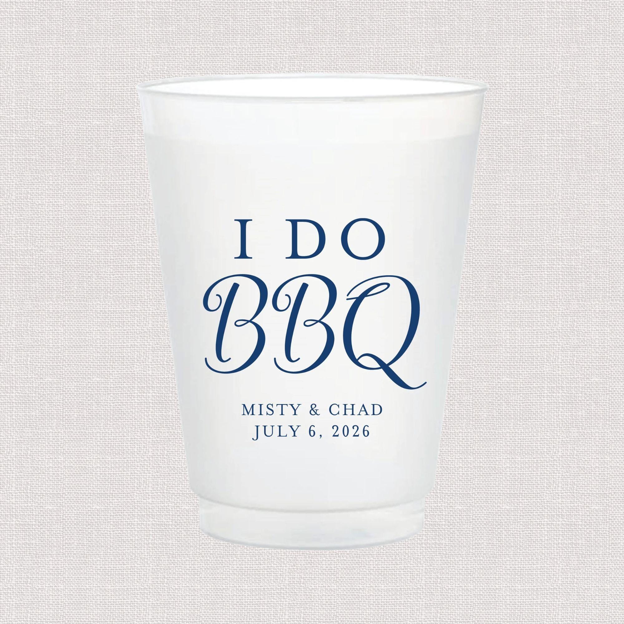 Frosted white cup with blue text reading "I DO BBQ" and personalized names "MISTY & CHAD" with date "JULY 6, 2026"