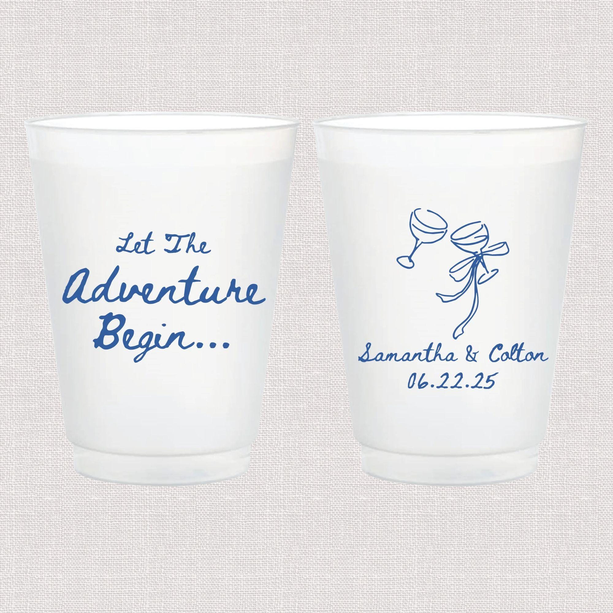 Pair of frosted white cups with blue script text reading "Let The Adventure Begin" and a champagne glass design with "Samantha & Cotton 06.22.25"
