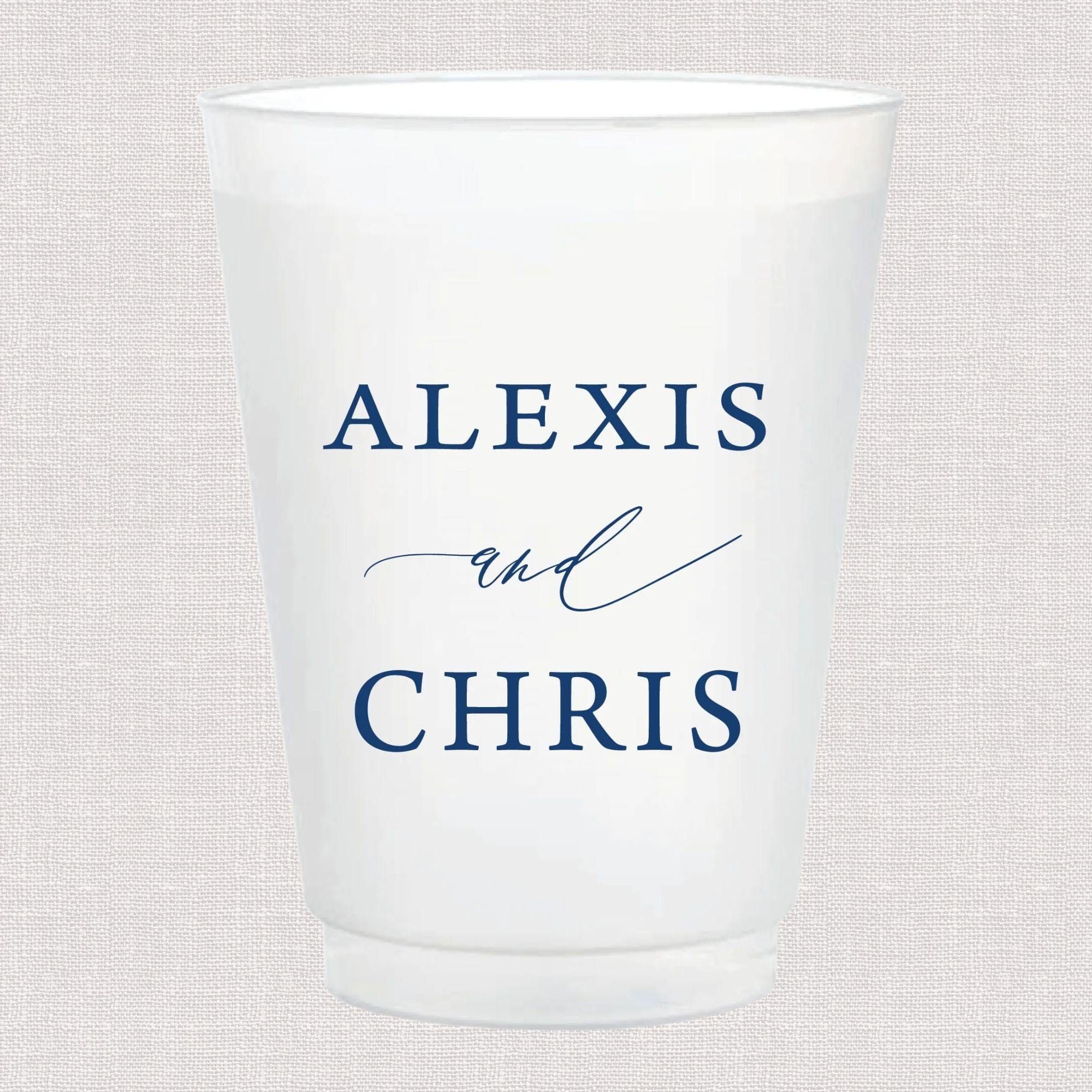 Frosted white cup with "ALEXIS and CHRIS" in blue lettering and decorative ampersand design