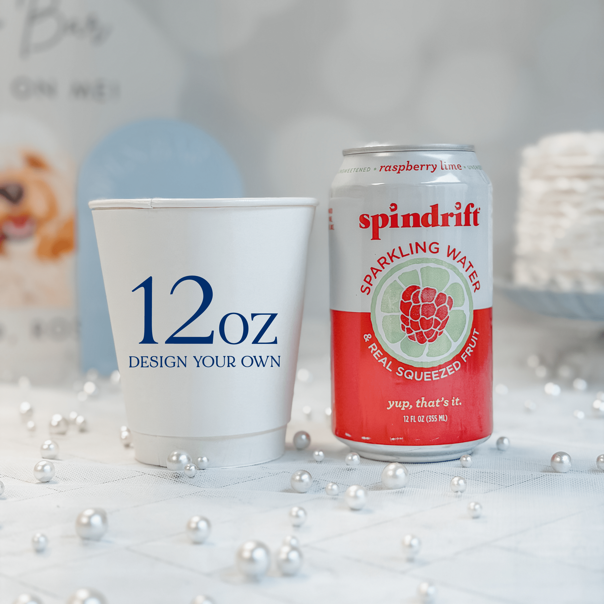 12 oz white paper cup next to a 12 oz soda can for scale, custom navy design
