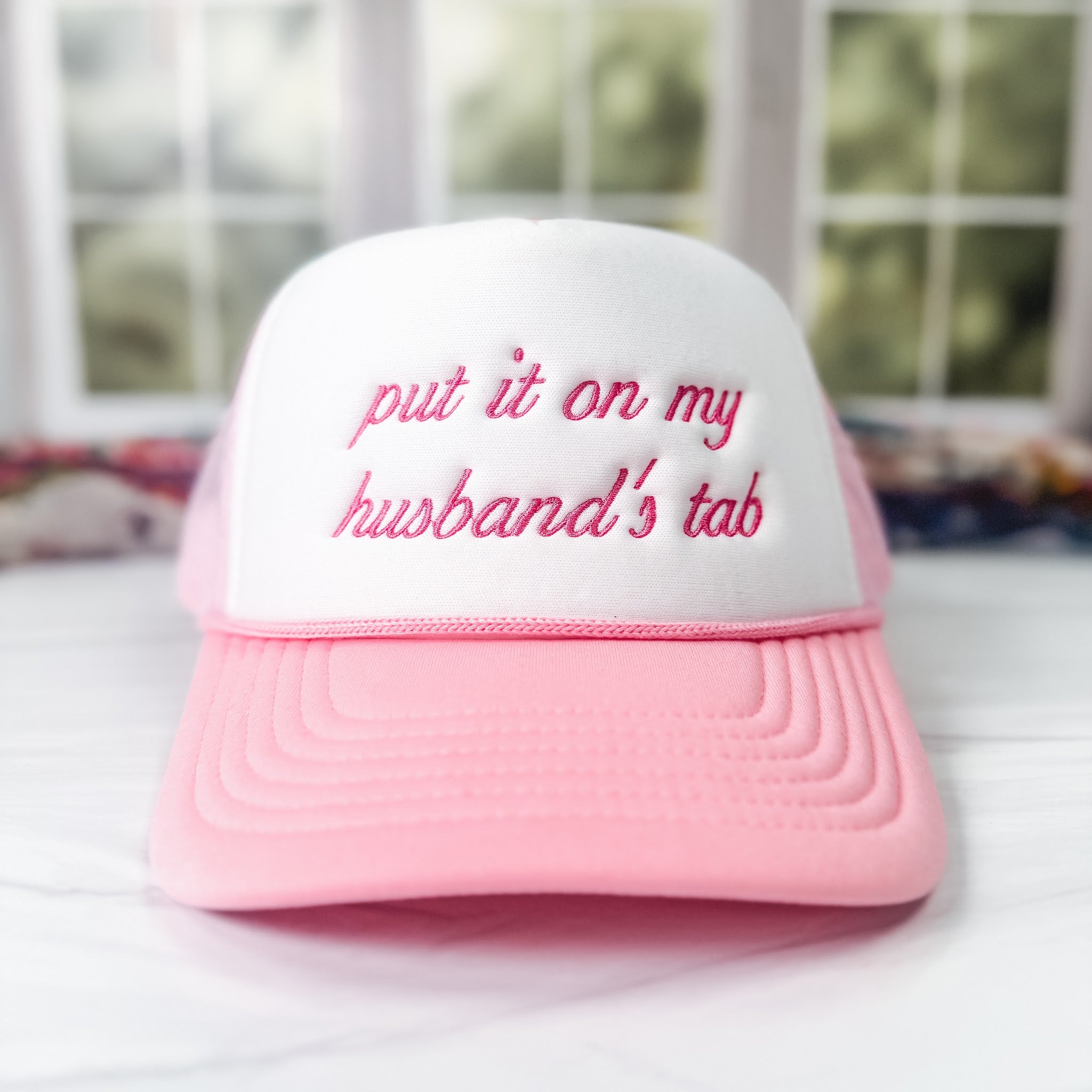 Embroidered foam trucker cap reading put it on my husband's tab