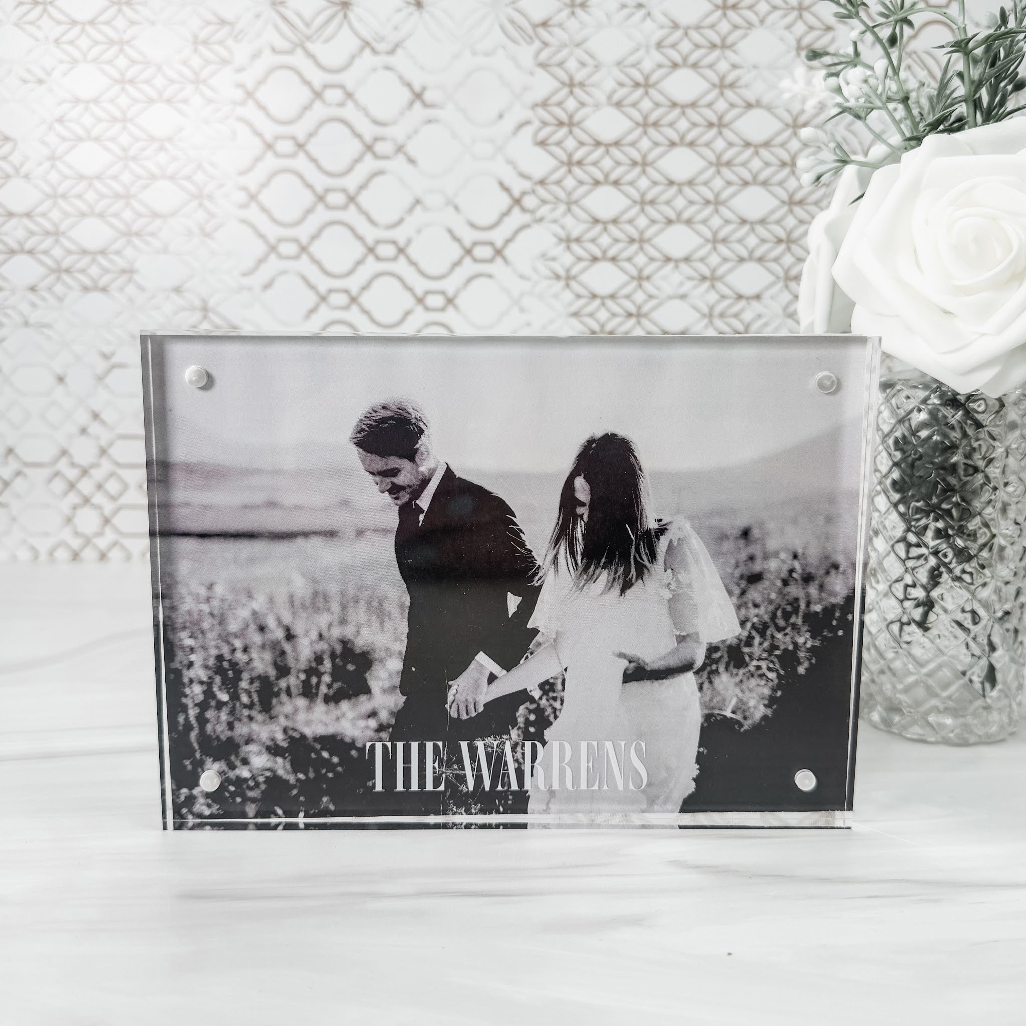 Personalized clear acrylic photo frame UV-printed with last name, holding a couple photo