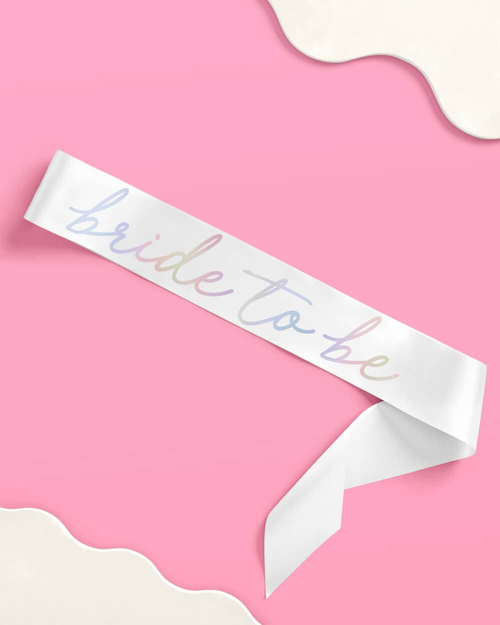 White sash with iridescent foil "bride to be" text on pink background.