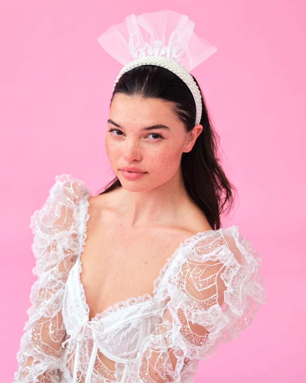 White lace bride headband with pearl accents and "bride" text on pink background