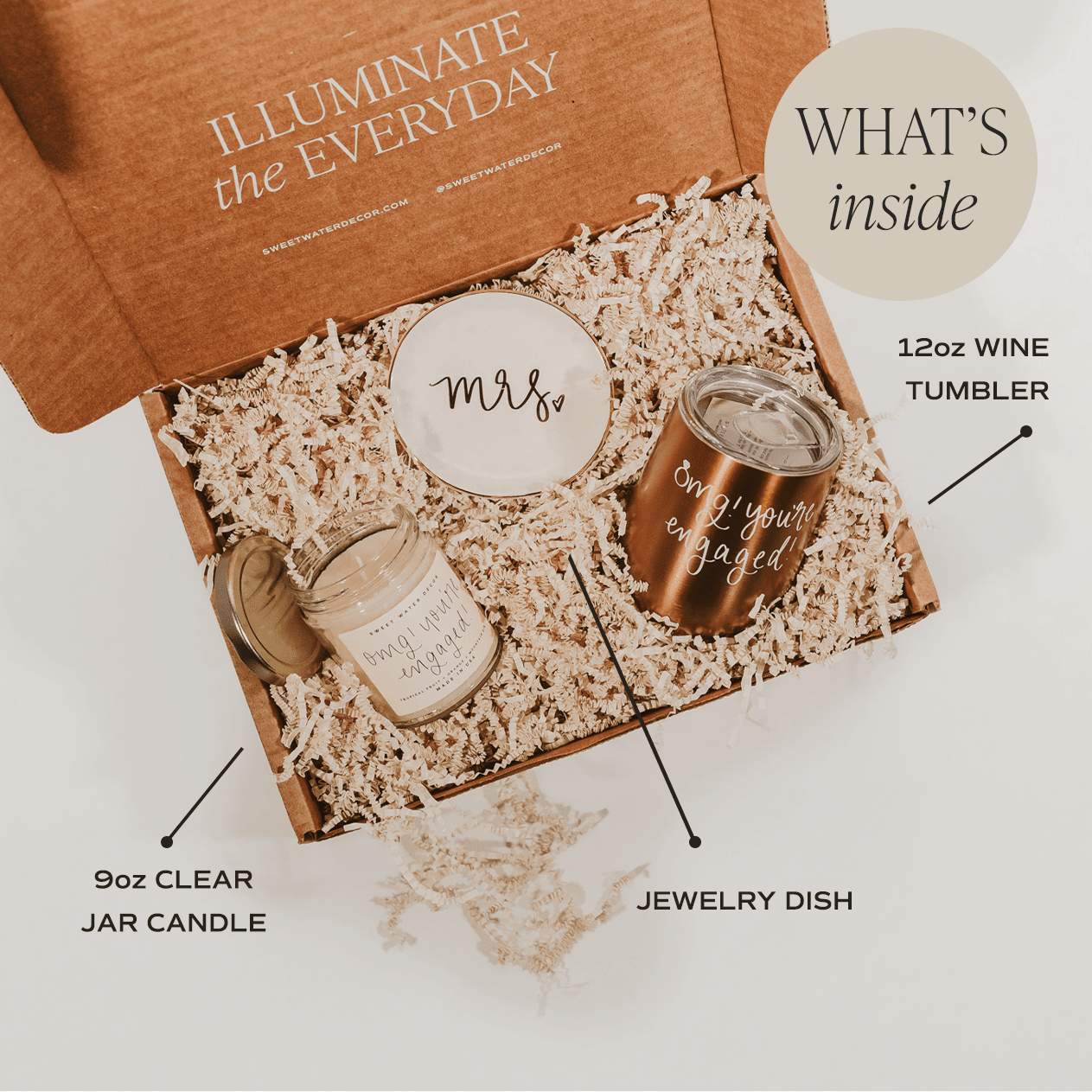 Unboxing view of Miss to Mrs. gift box with rose gold wine tumbler, clear jar candle, jewelry dish, and cream packing material.