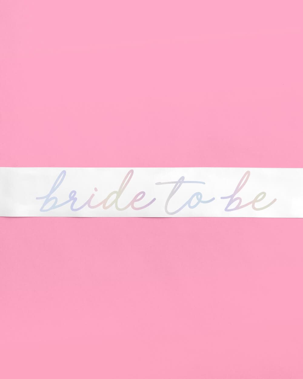 White sash with iridescent foil "bride to be" text on pink background