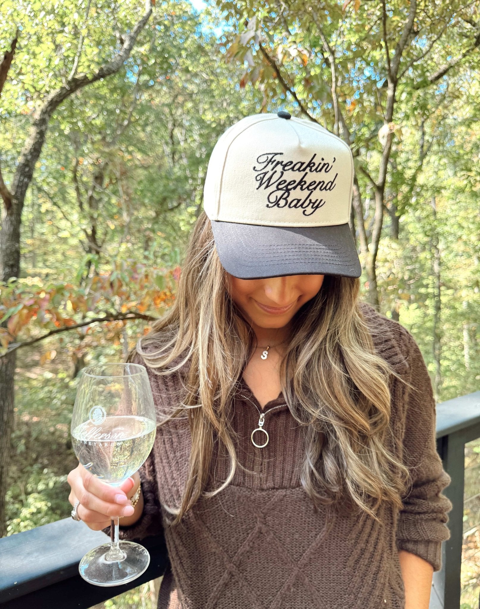 White and gray vintage trucker hat with "Freakin' Weekend Baby" embroidered script text on front panel.
