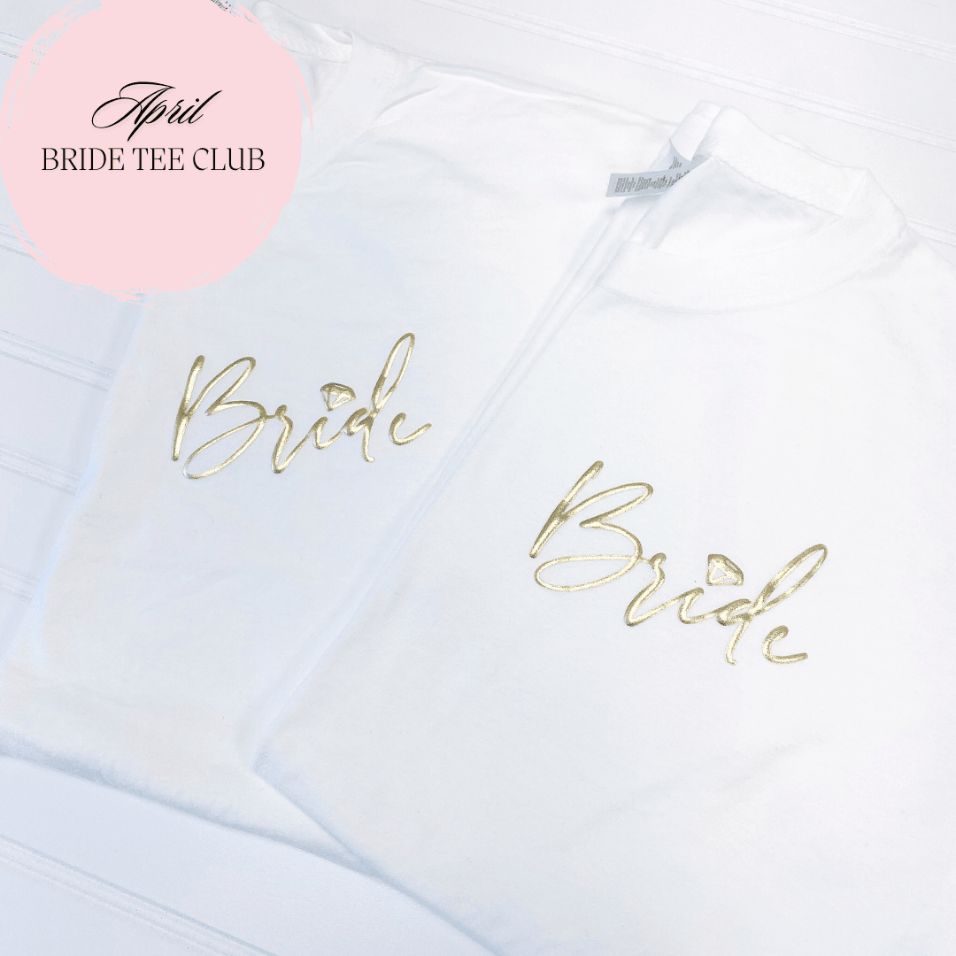White t-shirts with gold foil "Bride" and "Bridal" text, part of Liquid Bride Tee Club subscription service for personalized bridal apparel.