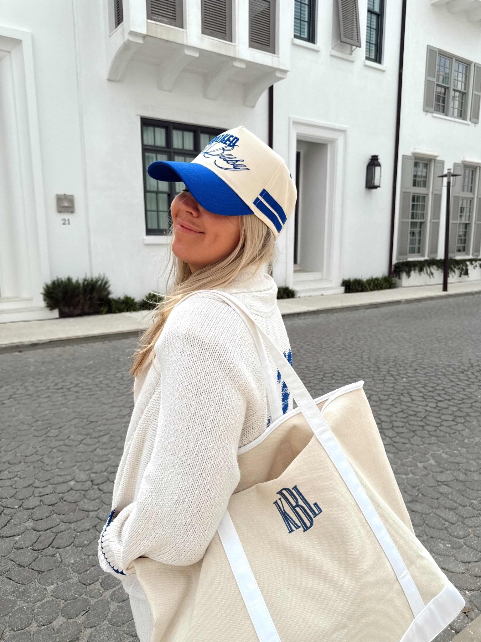 Woman wearing cream and blue vintage trucker hat with monogram, paired with matching canvas tote bag featuring personalized initials.