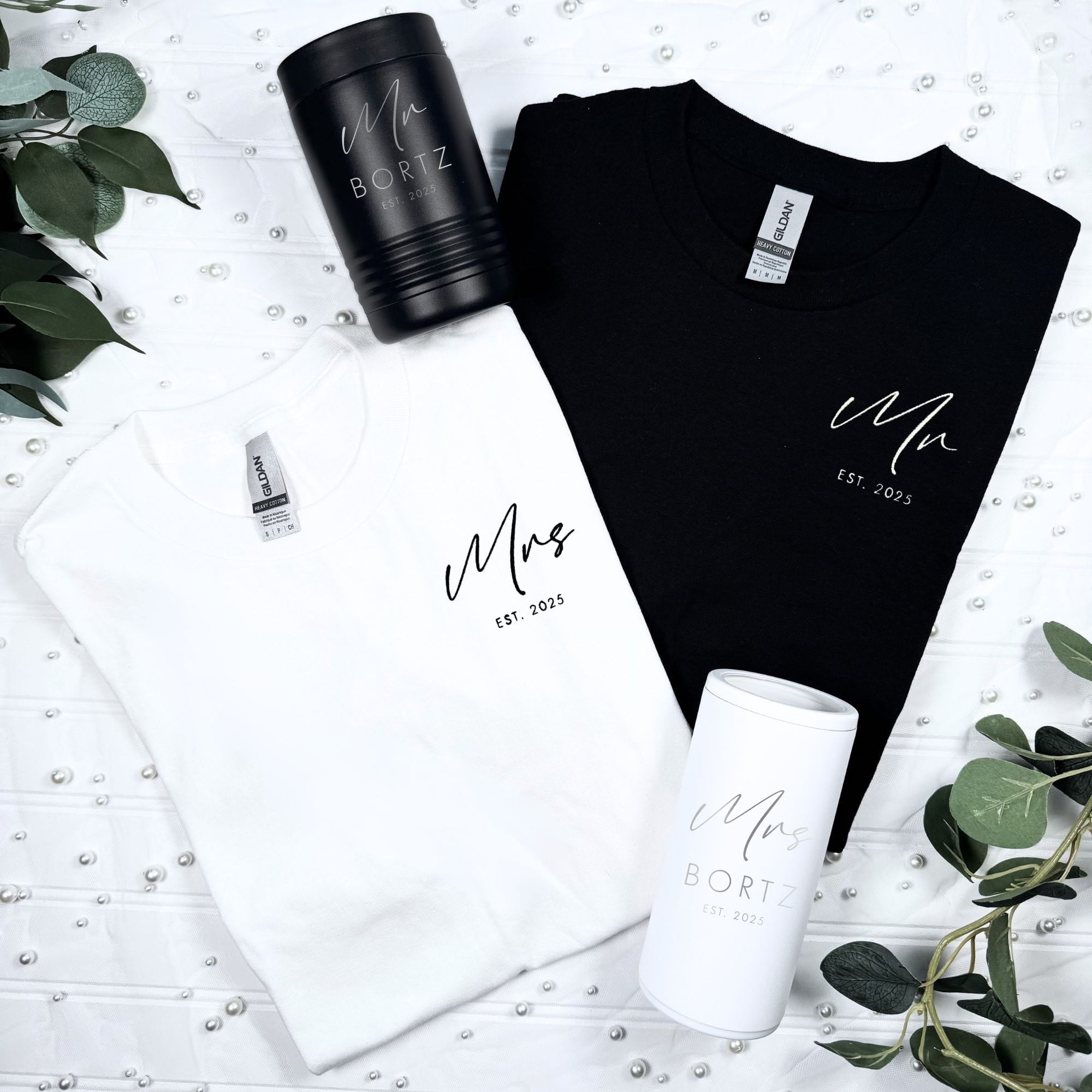 White and black sweatshirts with script text design, paired with black can coolers and white cosmetic jar, wedding gift set
