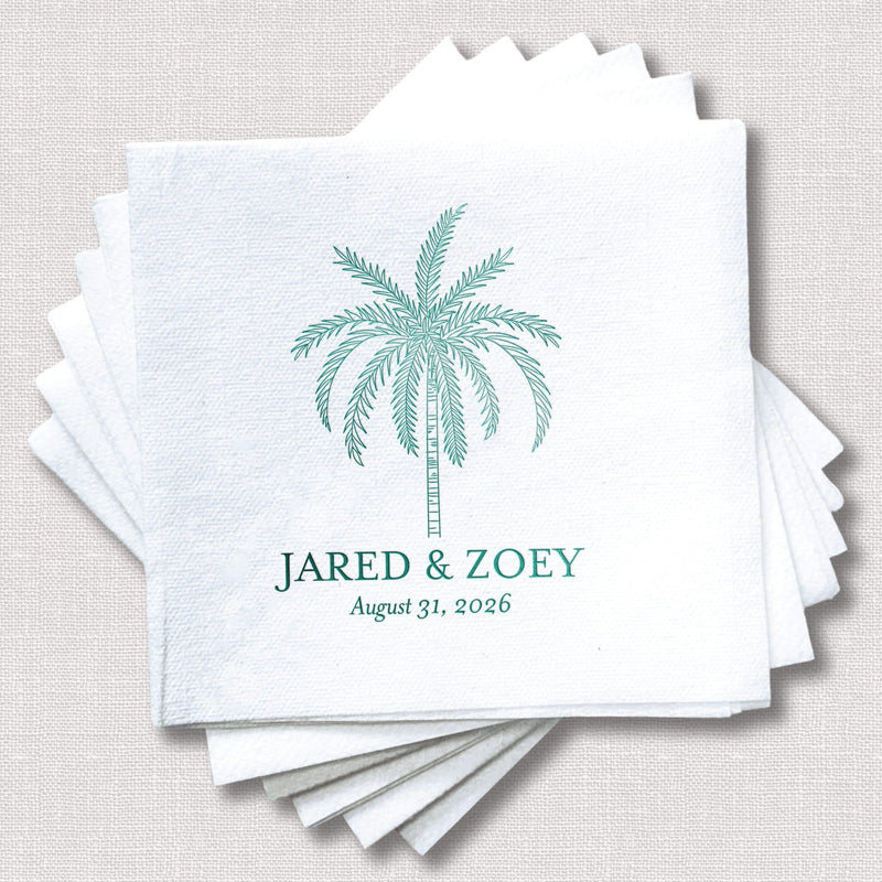 Stack of white linen napkins with teal foil-stamped palm tree design and personalized names "Jared & Zoey" with wedding date August 31, 2026.