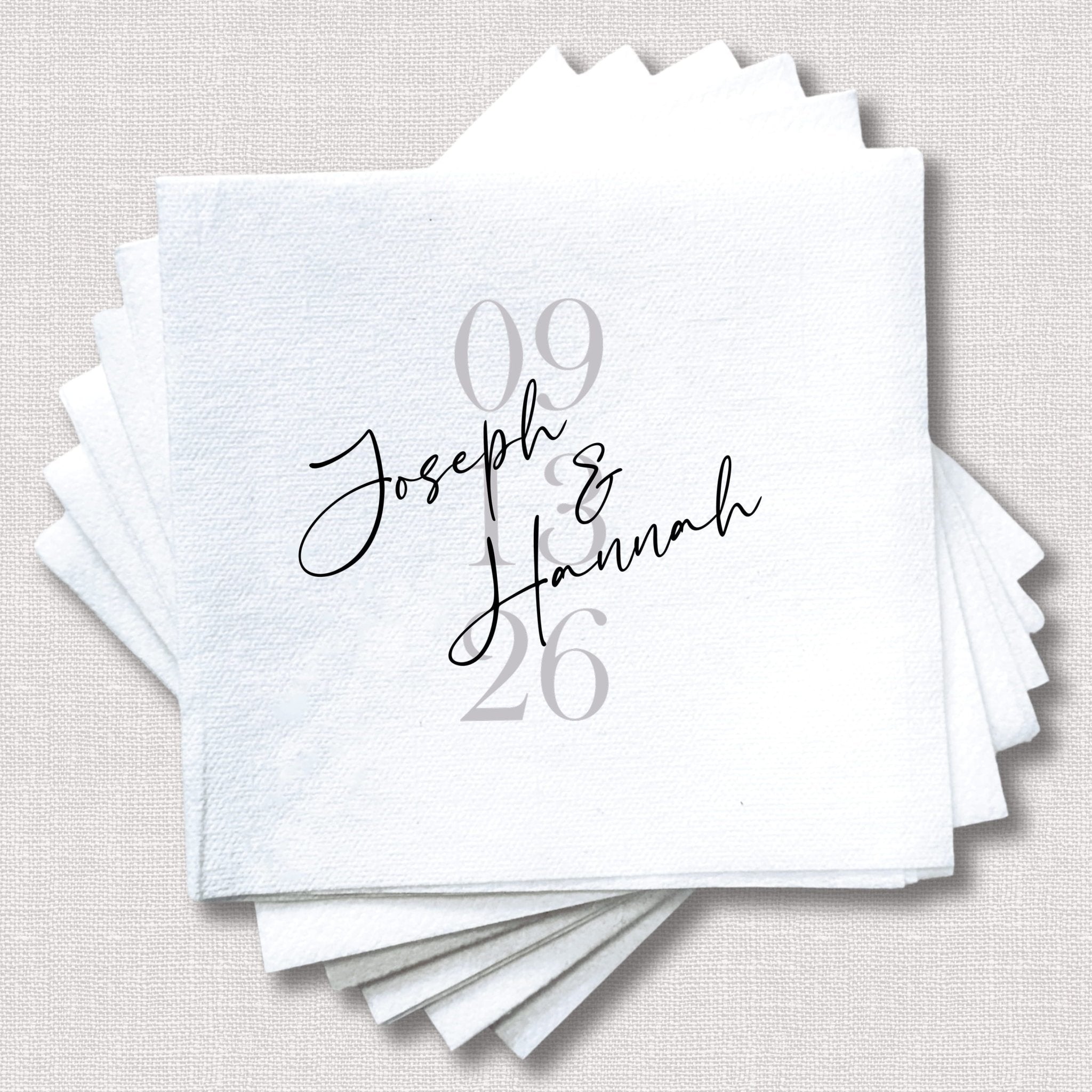 Stack of white cocktail napkins with "Joseph & Hannah" in script and "09.26" date in gray text