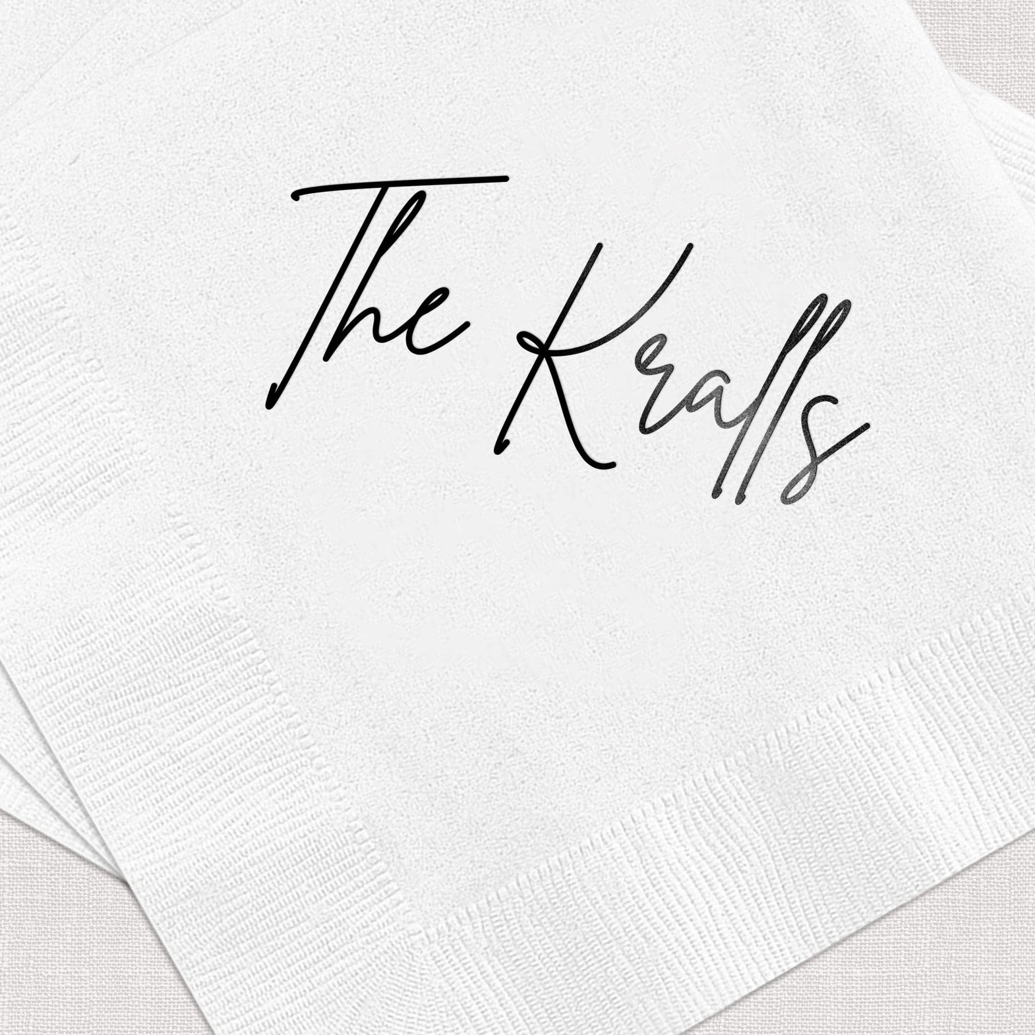 White cocktail napkins with "The Kralls" printed in elegant script lettering