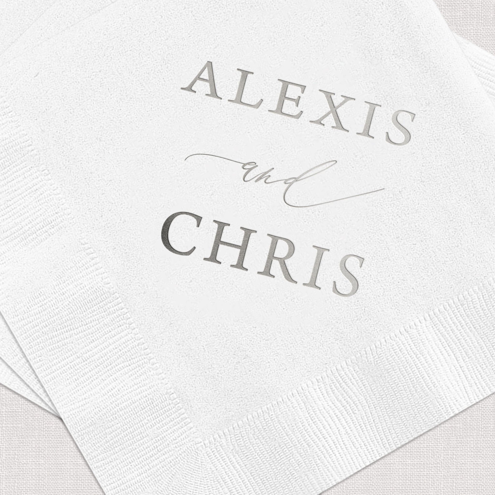 White cocktail napkins with "ALEXIS and CHRIS" personalized in gray foil lettering
