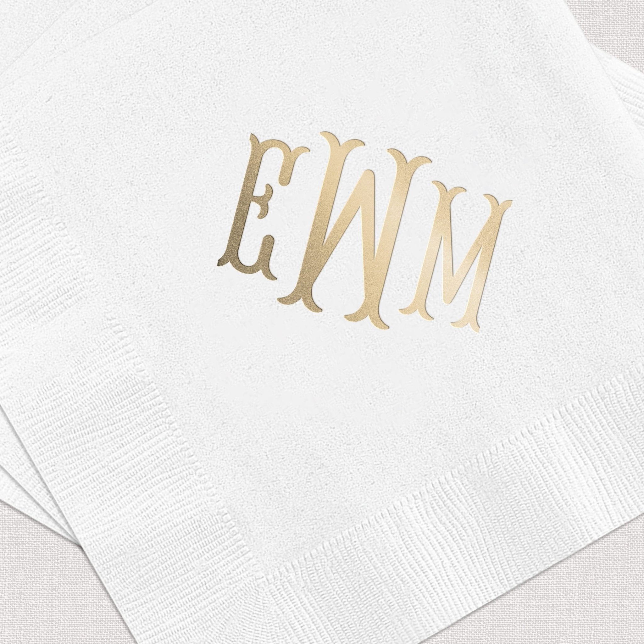 White napkin with gold foil monogram letters EWM printed in the center