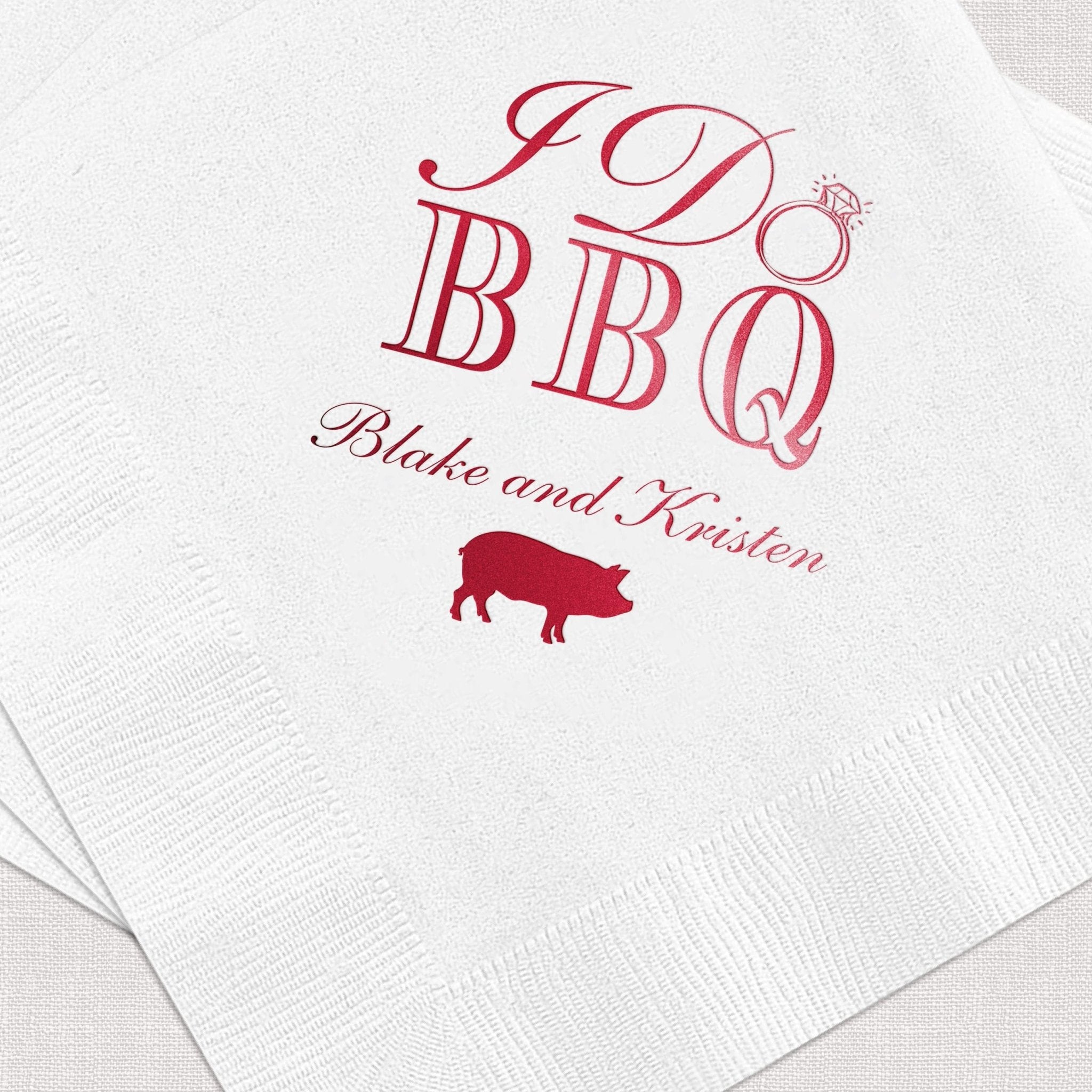 White napkin with red foil-stamped I Do BBQ design, pig icon, and personalized names Blake and Kirsten