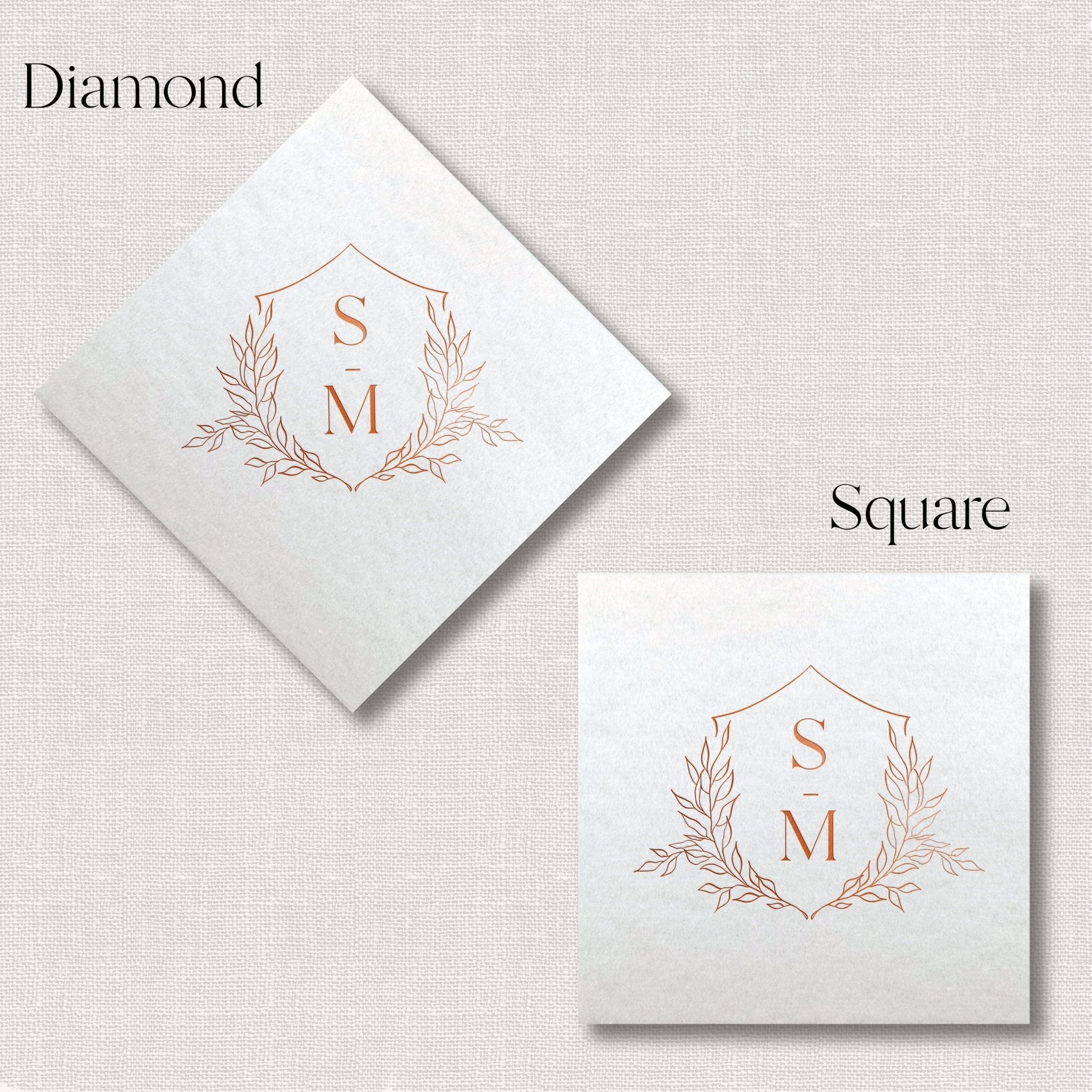 White linen napkins in diamond and square shapes featuring rose gold foil-stamped floral crest with initials S and M.