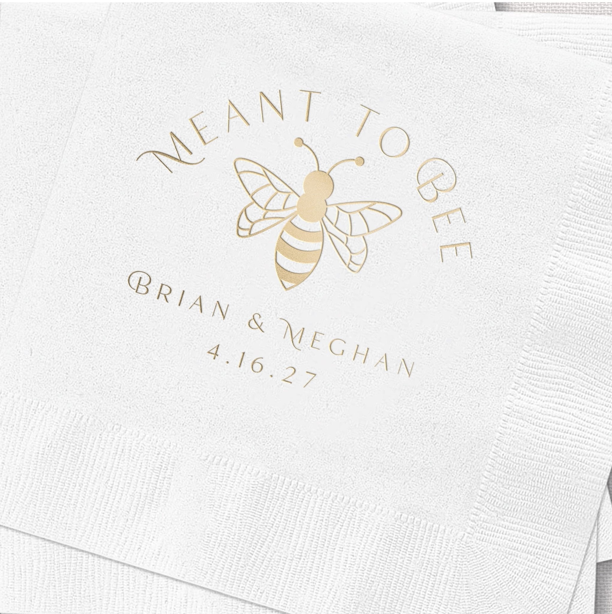 White napkin with gold foil bee design and "Meant to Bee" text, personalized with names Brian & Meghan and date 4.16.27