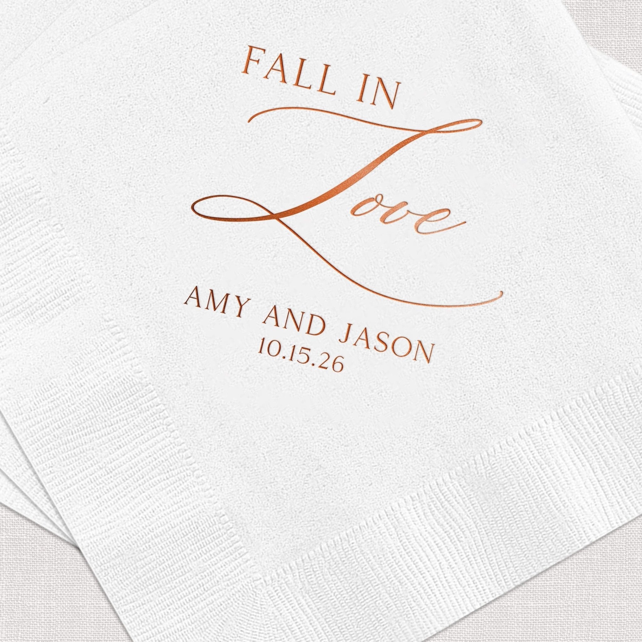 White napkin with copper foil-stamped text reading "Fall in Love" and "Amy and Jason 10.15.26"