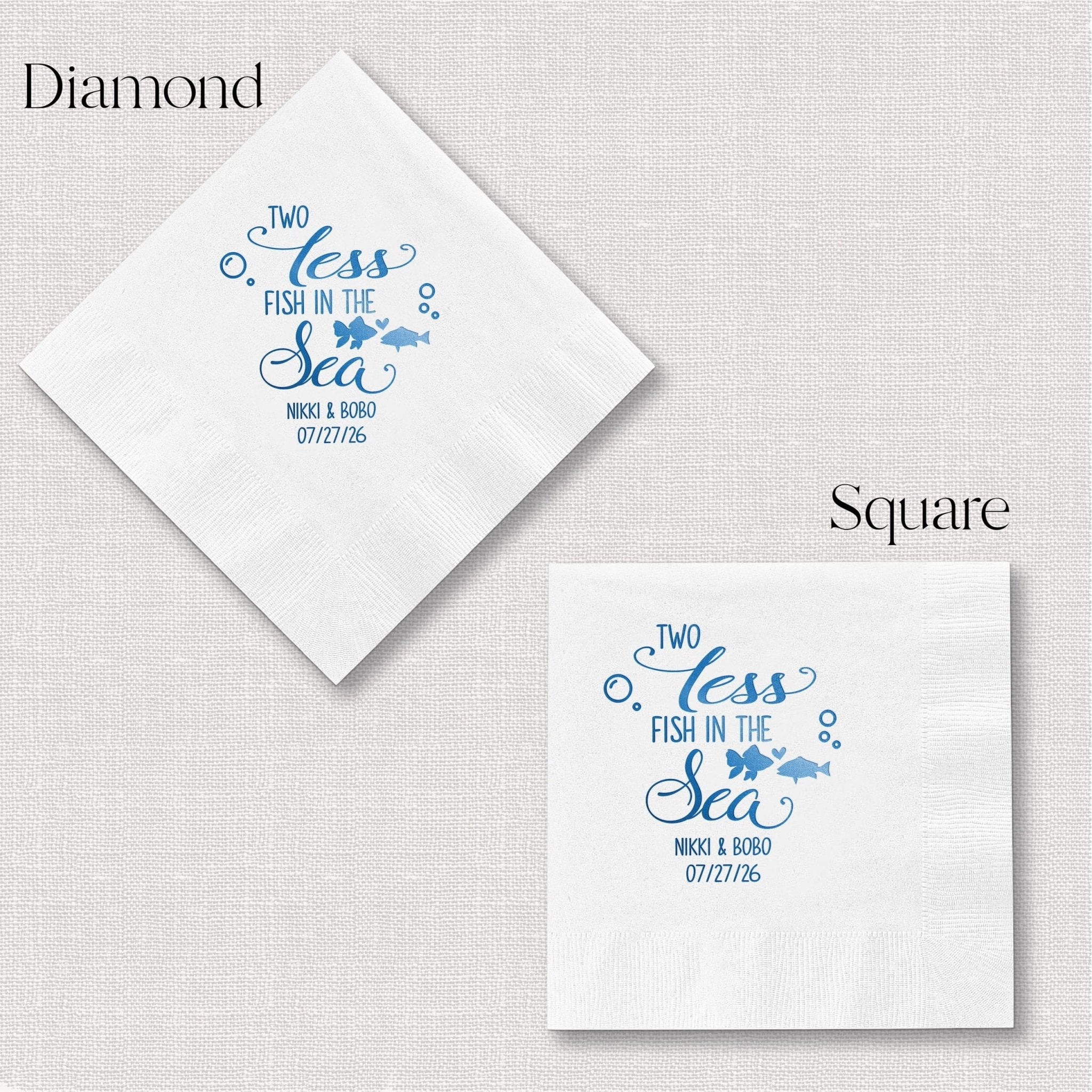 White napkins in diamond and square shapes with blue foil-stamped "Two Less Fish in the Sea" design and personalized wedding date.