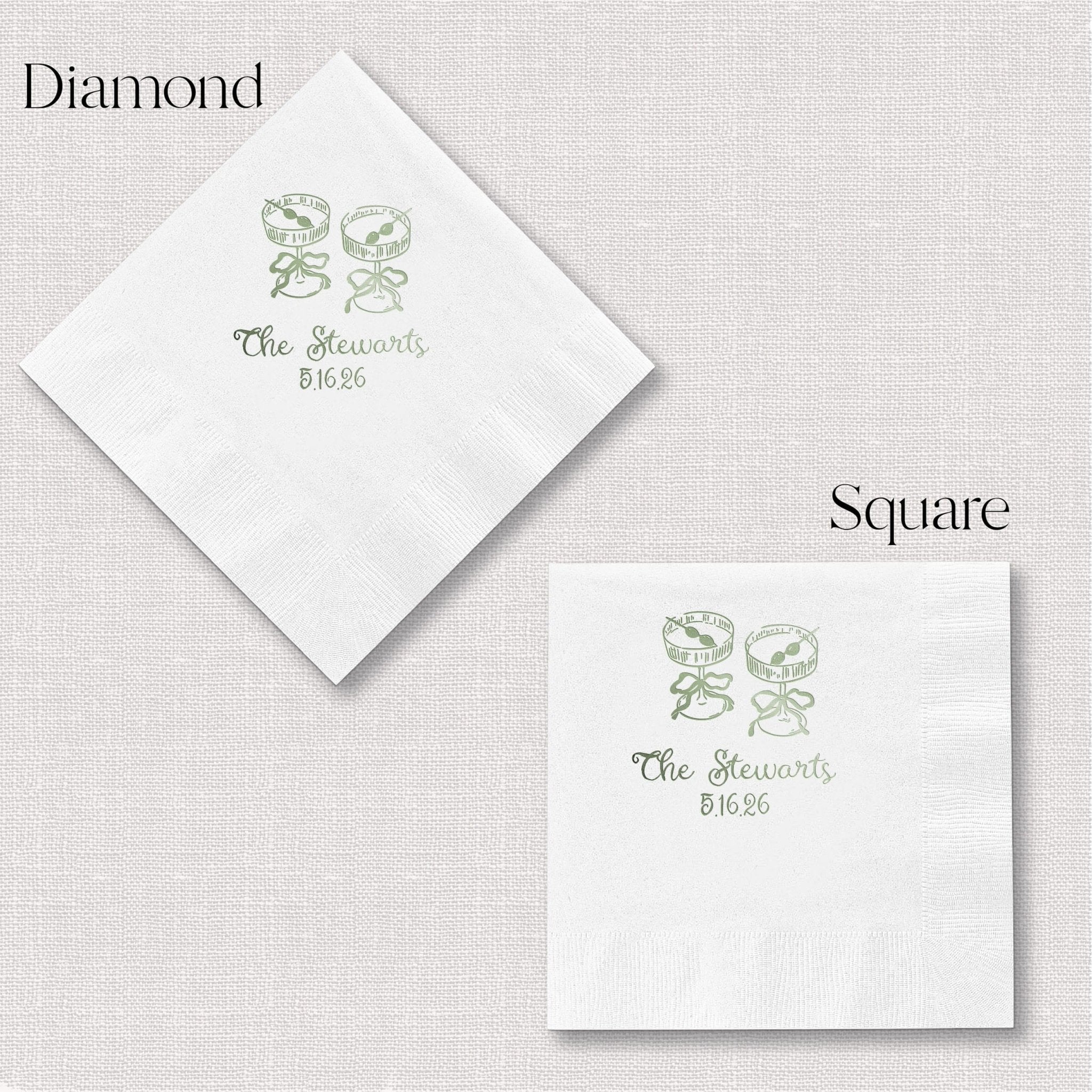 White cocktail napkins with green foil-stamped design featuring two champagne glasses and "The Blossoms 8/16/25" text, shown in diamond and square fold styles.