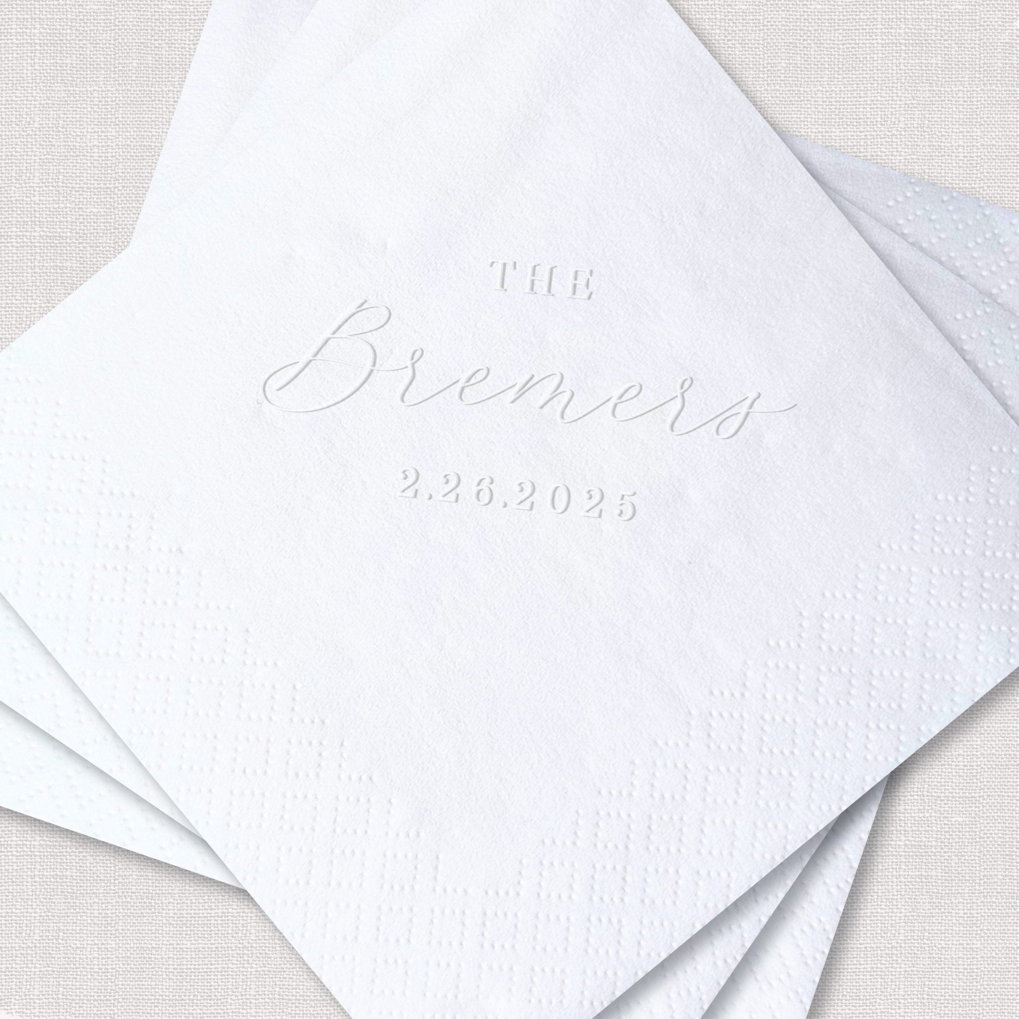 White embossed napkins with "The Brewers" and wedding date 2.28.2025 printed in elegant script