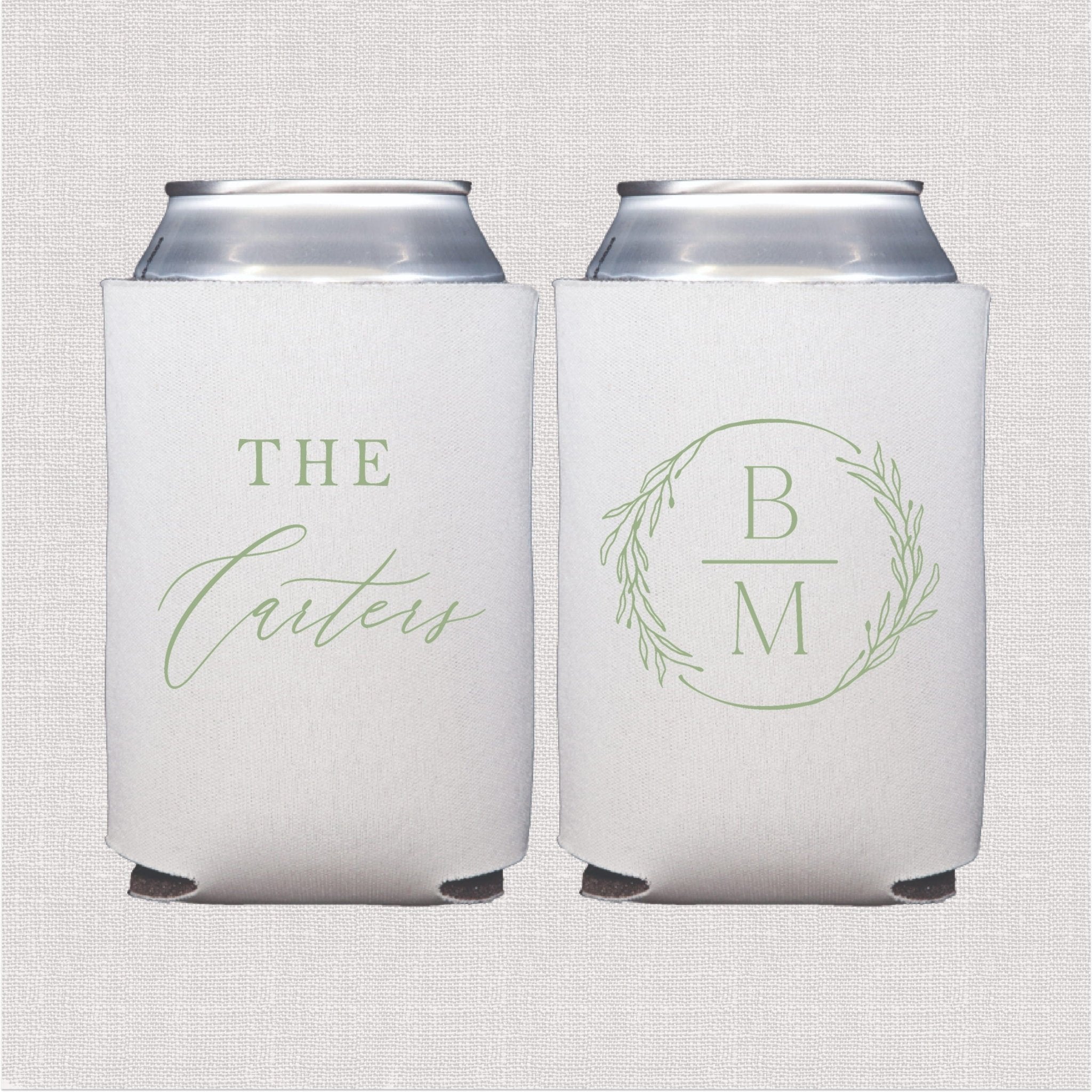 Pair of white can coolers with sage green personalized designs, one with script text reading "THE" and "Carters" and the other with initials "B" and "M" in a wreath circle.