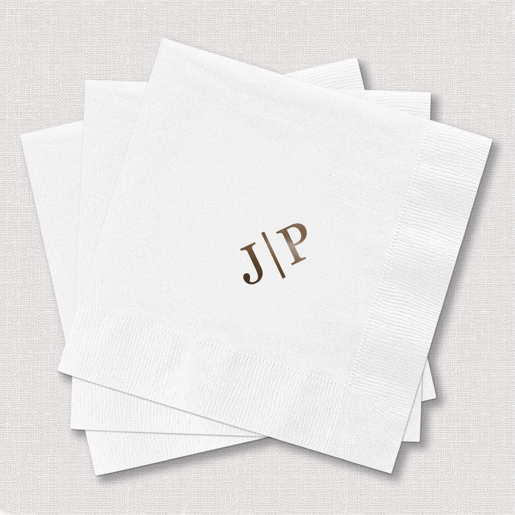 Stack of white foil-stamped napkins with gold monogram initials JIP