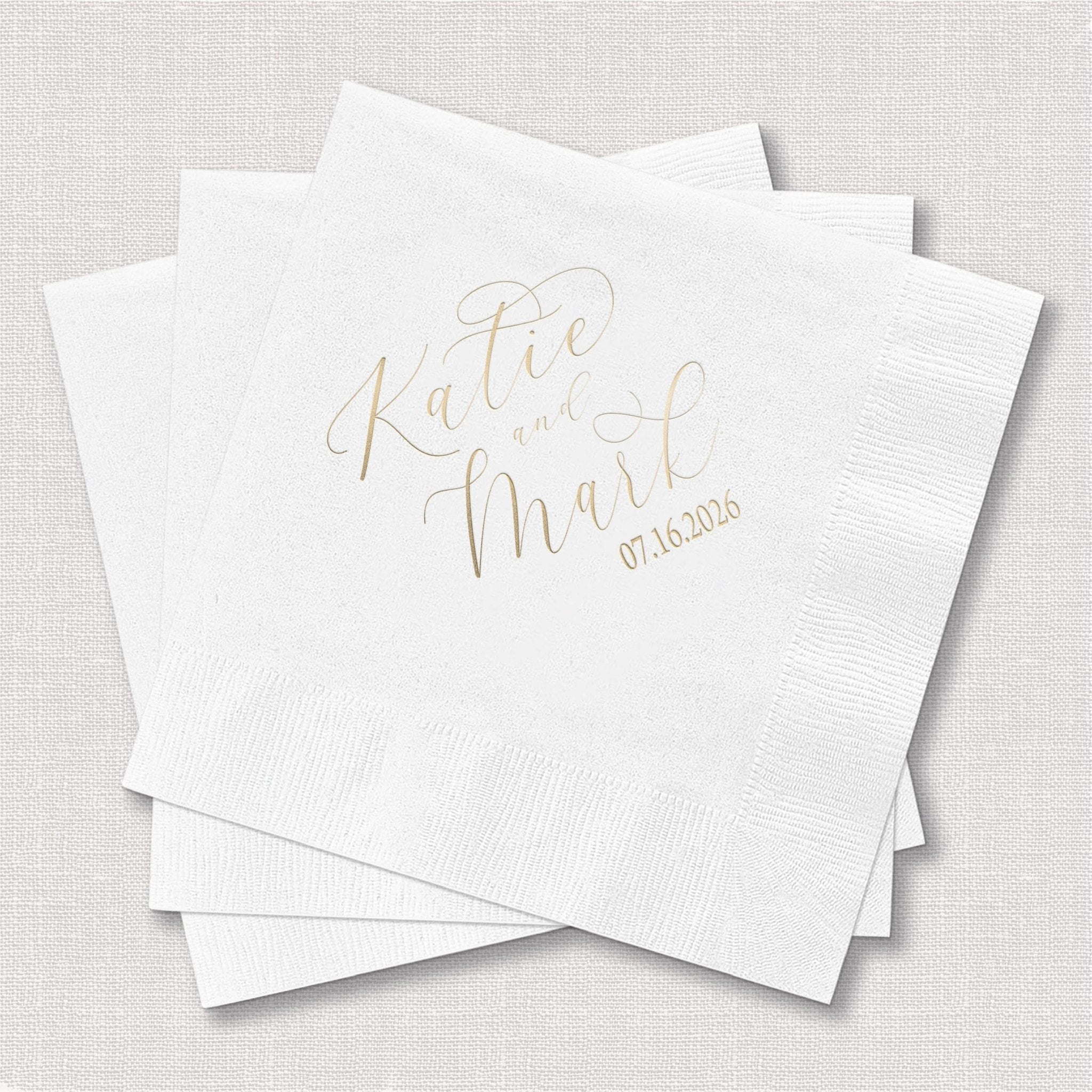 White cocktail napkins with gold foil stamped names Katie and Maral and wedding date 07.16.2015