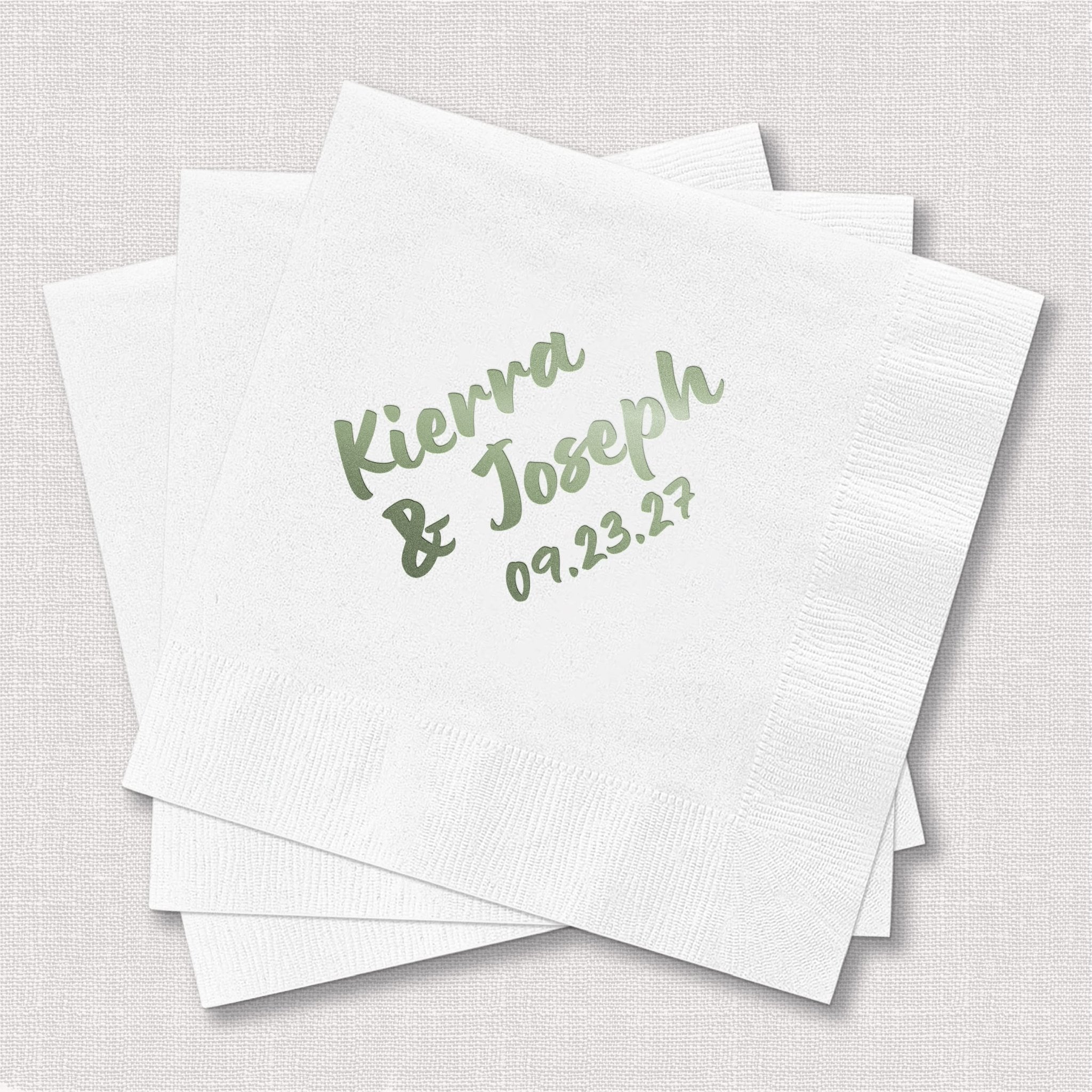 White cocktail napkins with sage green foil-stamped names "Kieran & Joseph" and date "09.23.17"