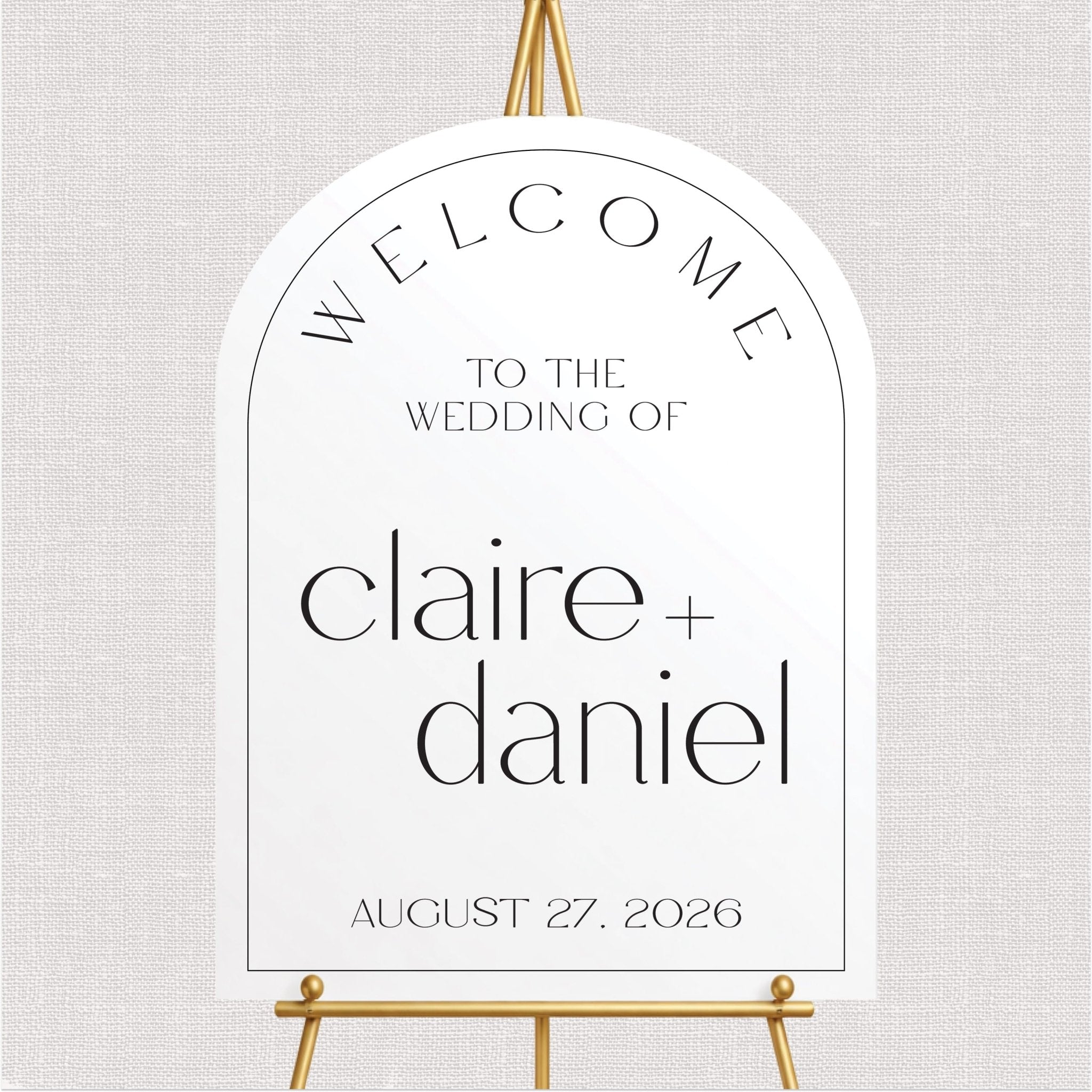 White arch-shaped welcome sign with personalized wedding couple names and date in black text