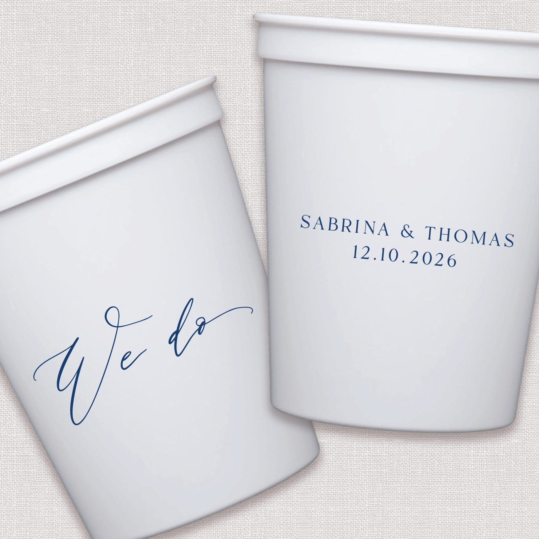 White stadium cups with personalized couple names and wedding date in navy script text