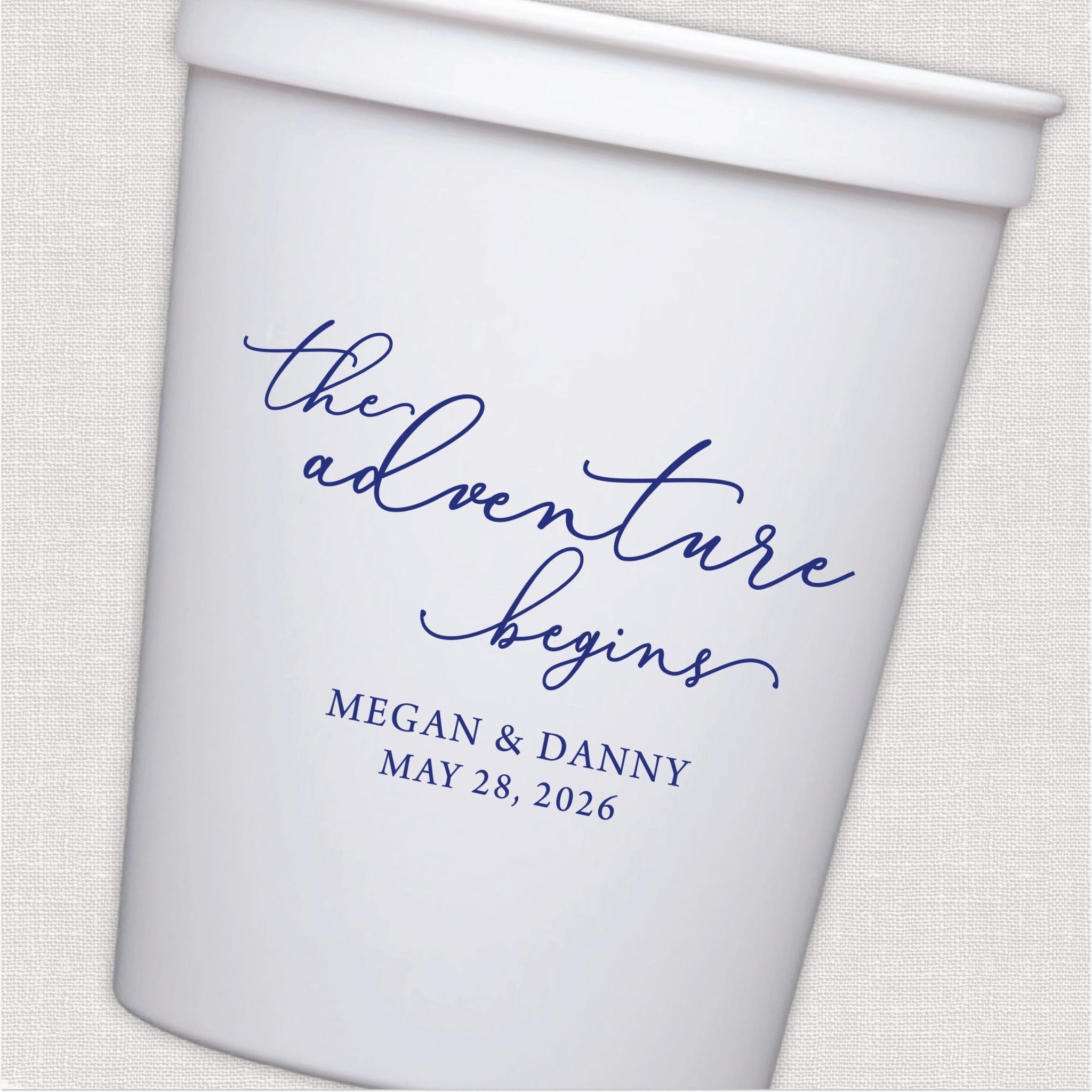 White stadium cup with script the adventure begins wedding text in navy blue