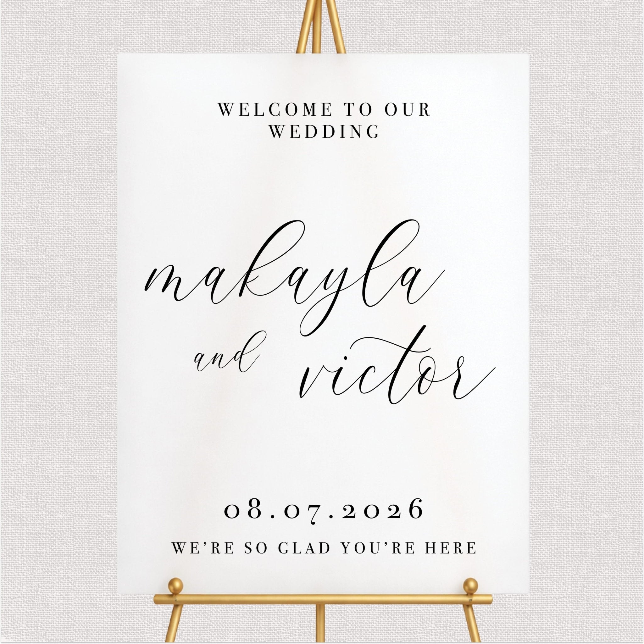 White wedding welcome sign with script couple names, wedding date, and black text on cream background