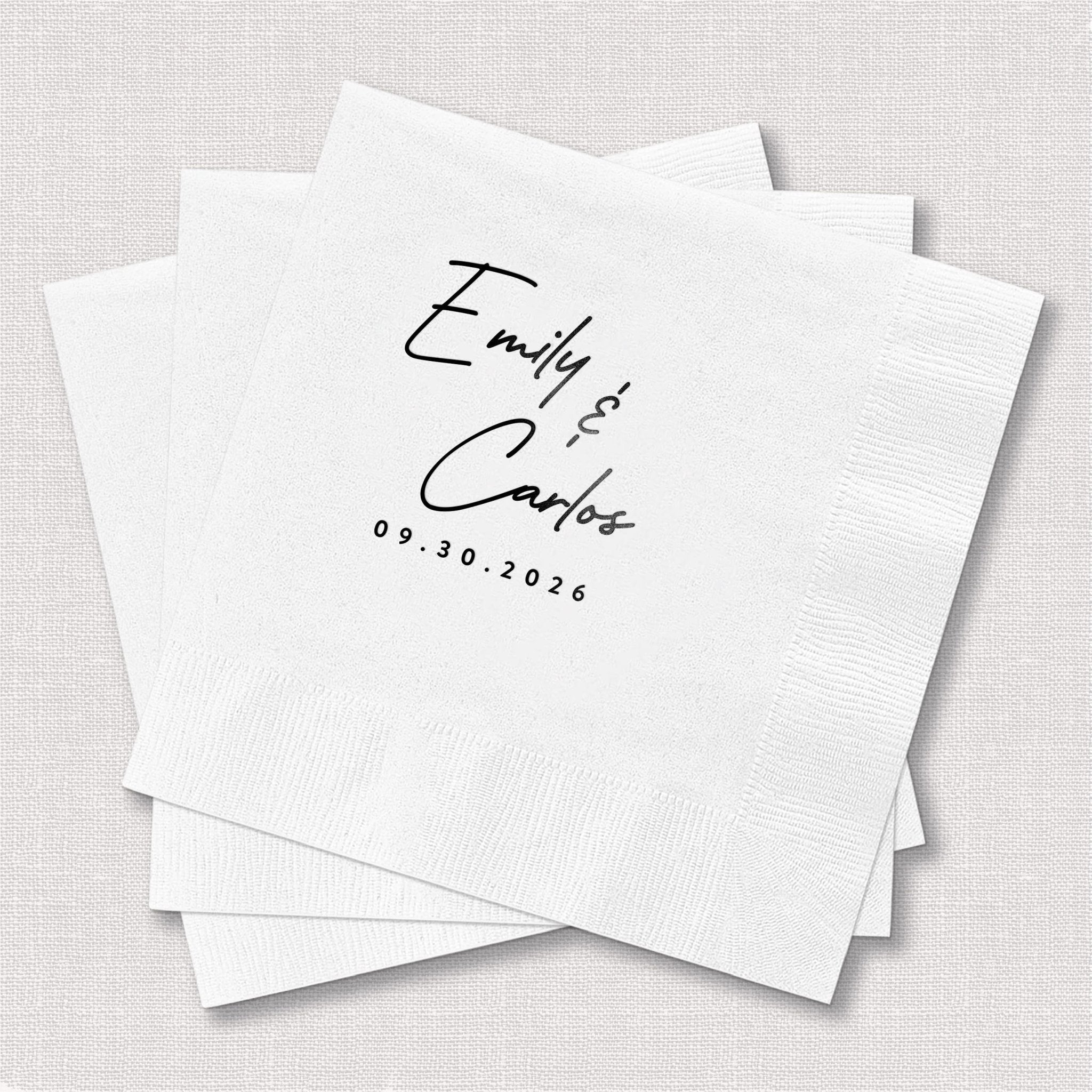 Stack of white napkins with handwritten "Emily and Carter" script and date 09.30.2026 in black ink.