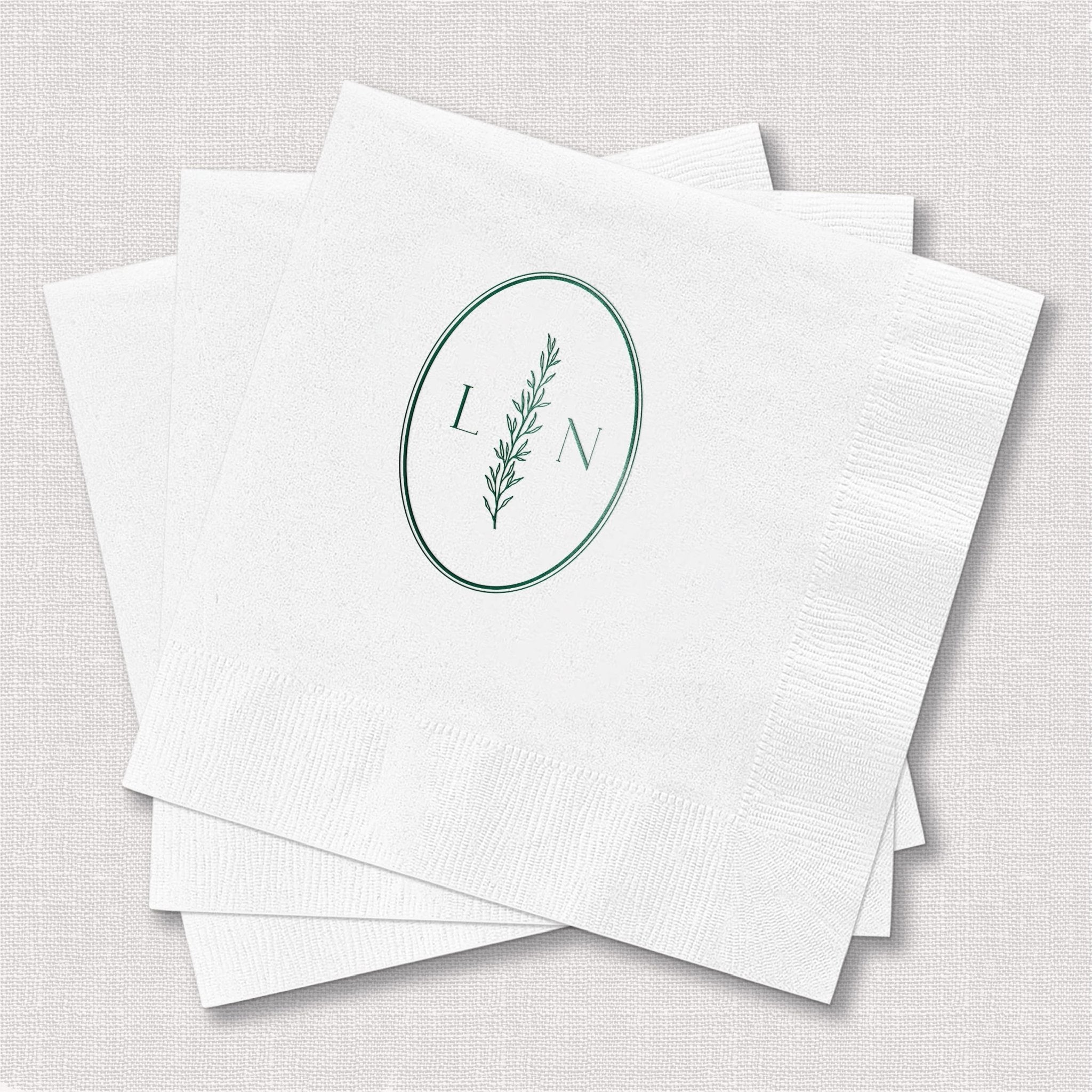White cocktail napkins with sage green botanical oval monogram featuring initials L and N