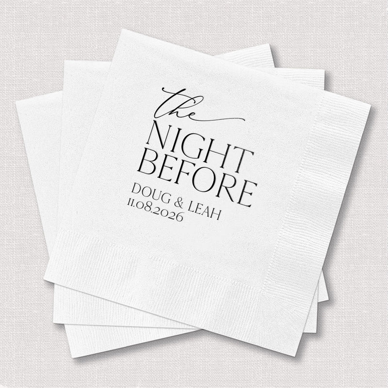 White cocktail napkins with "The Night Before" script and personalized names and date in elegant black foil stamping.