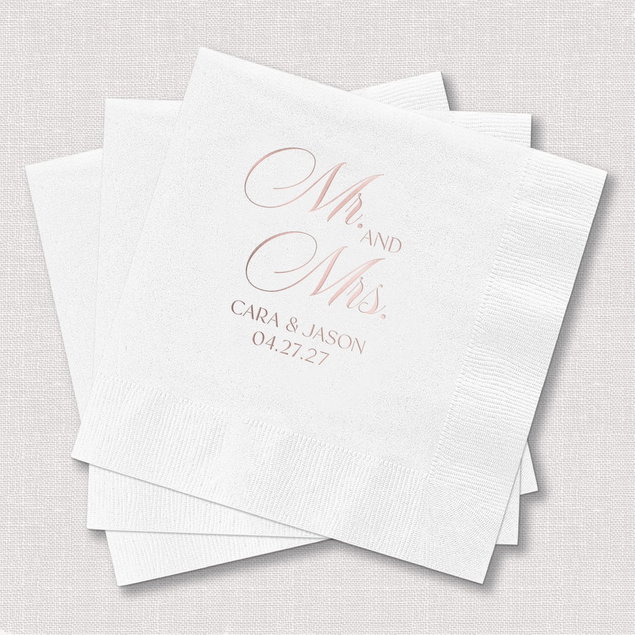 White cocktail napkins with rose gold foil stamped Mr and Mrs design, personalized with couple's names and wedding date.