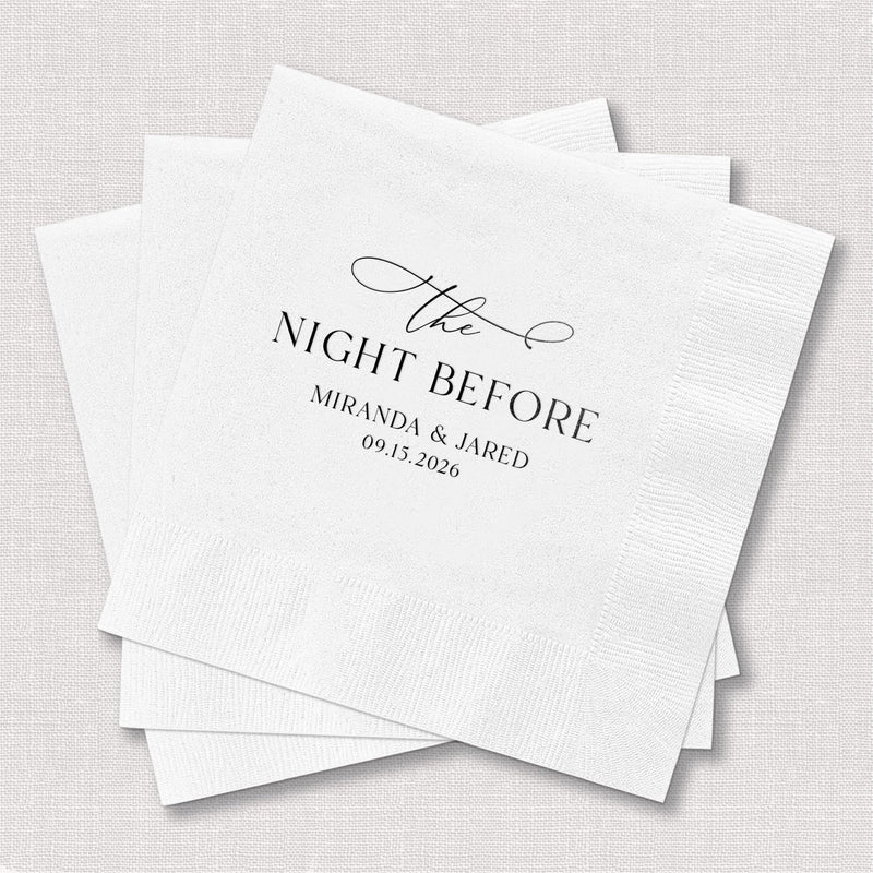 Stack of white cocktail napkins with "The Night Before" text and personalized names "Miranda & Jared" with date 09.13.2024 in elegant foil stamping.