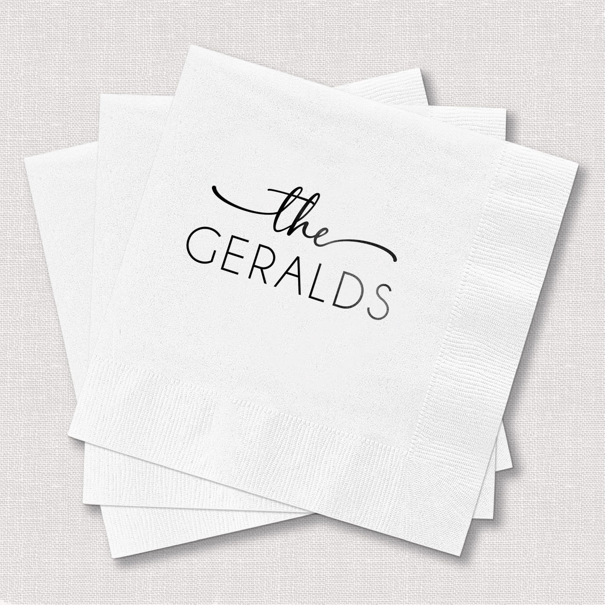 Stack of white napkins personalized with "the GERALDS" in black script text