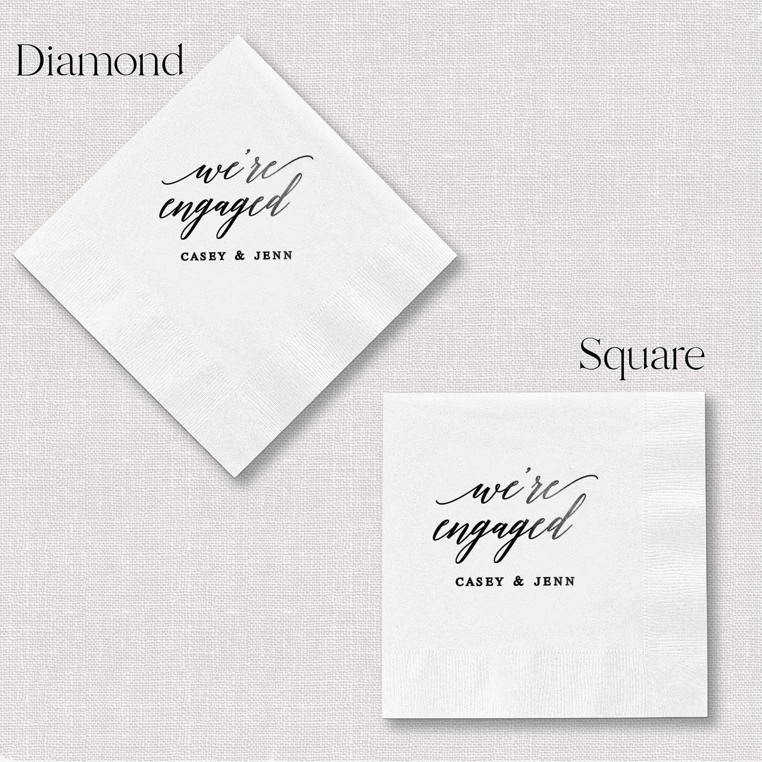 White napkins in diamond and square shapes with "we're engaged" script and personalized names in foil stamping