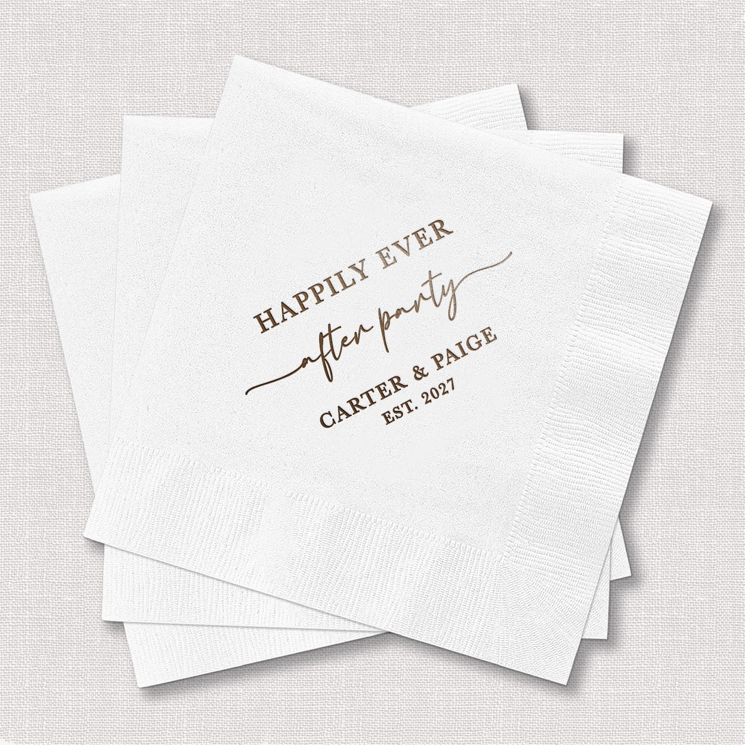 Stack of personalized white cocktail napkins with Happily Ever After Party design in gold serif and script typography