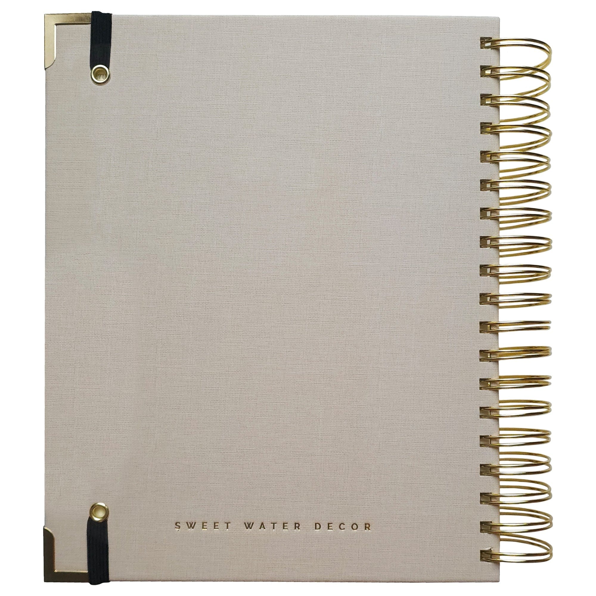 Cream linen spiral-bound recipe book with gold metal rings, black corner ties, and "Sweet Water Decor" text on cover.
