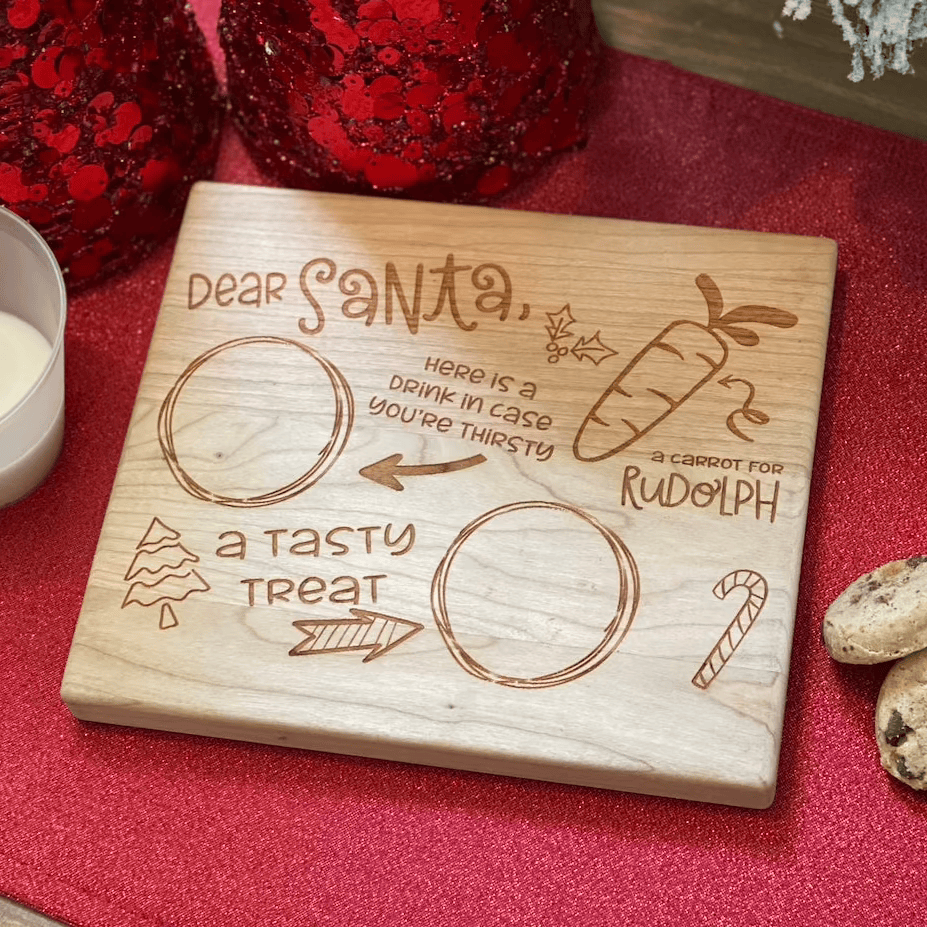 Engraved wooden Santa treat tray with "Dear Santa" text, circular spaces for cookies and milk, carrot for reindeer, and candy cane design on red holiday background.