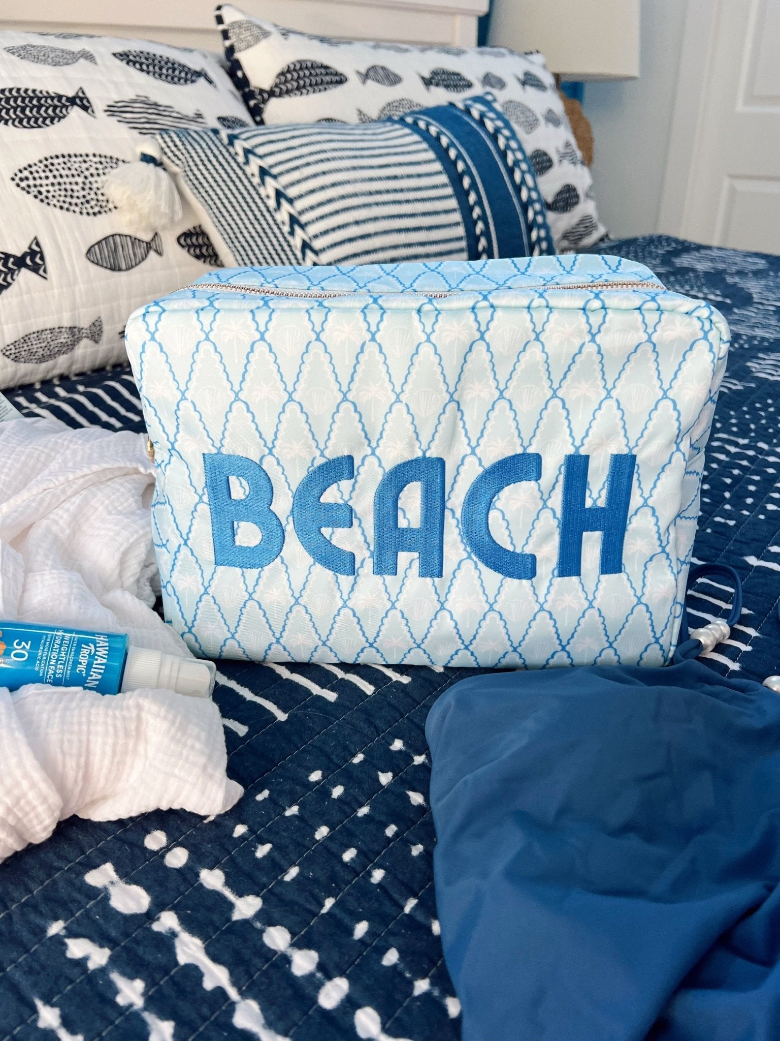 Blue and white quilted makeup bag with "BEACH" text and geometric diamond pattern design