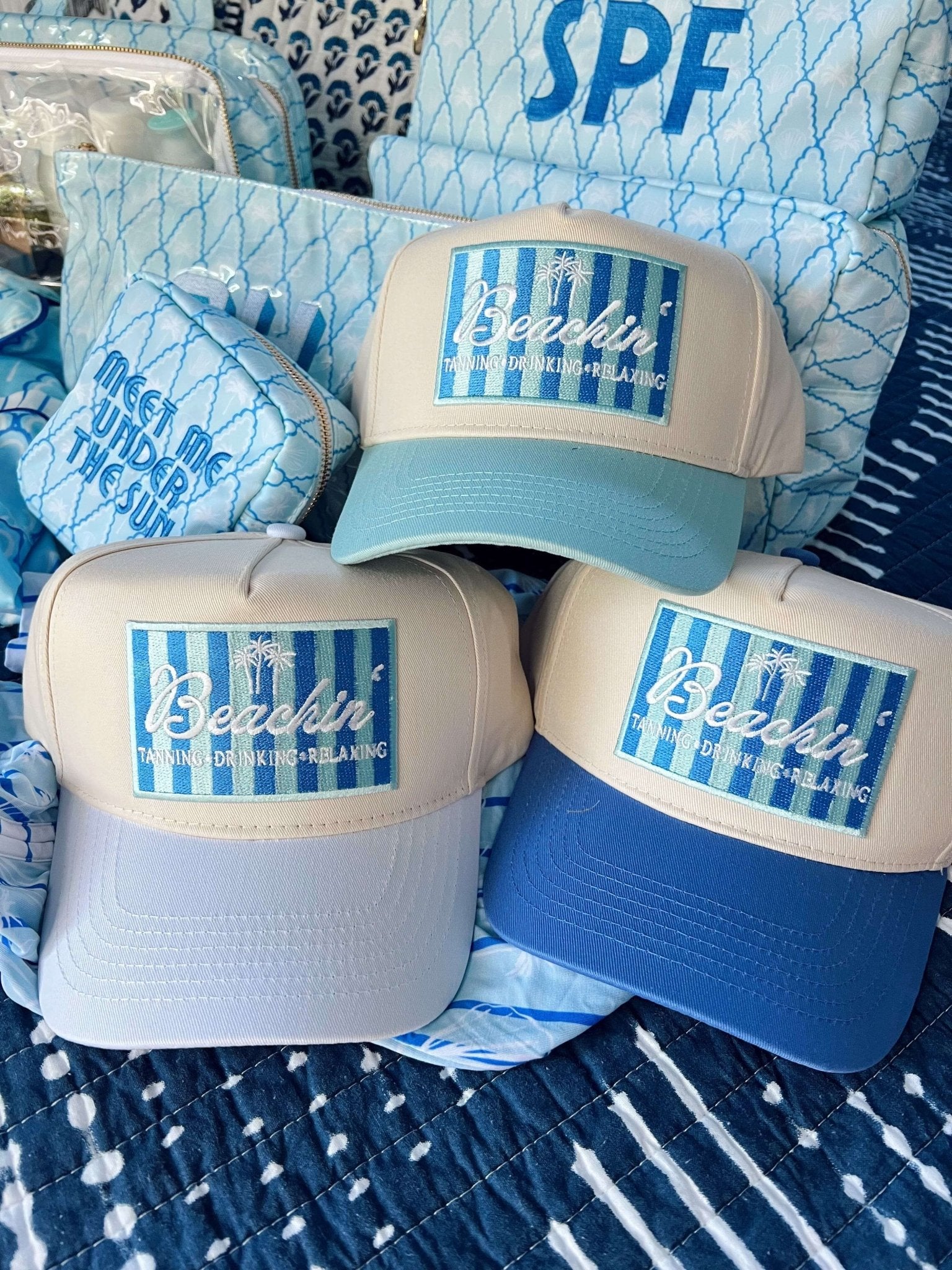 Blue and white vintage trucker hats with "Beachin'" text and striped design on front panels, displayed in a group of three.