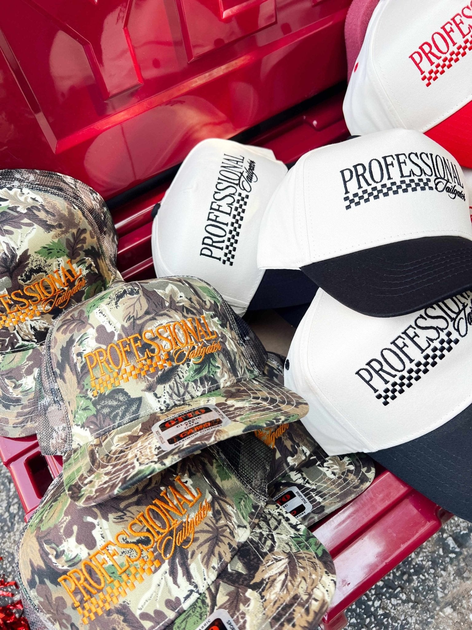 Vintage trucker hats in camo and white with "Professional Tailgater" text and checkered flag design