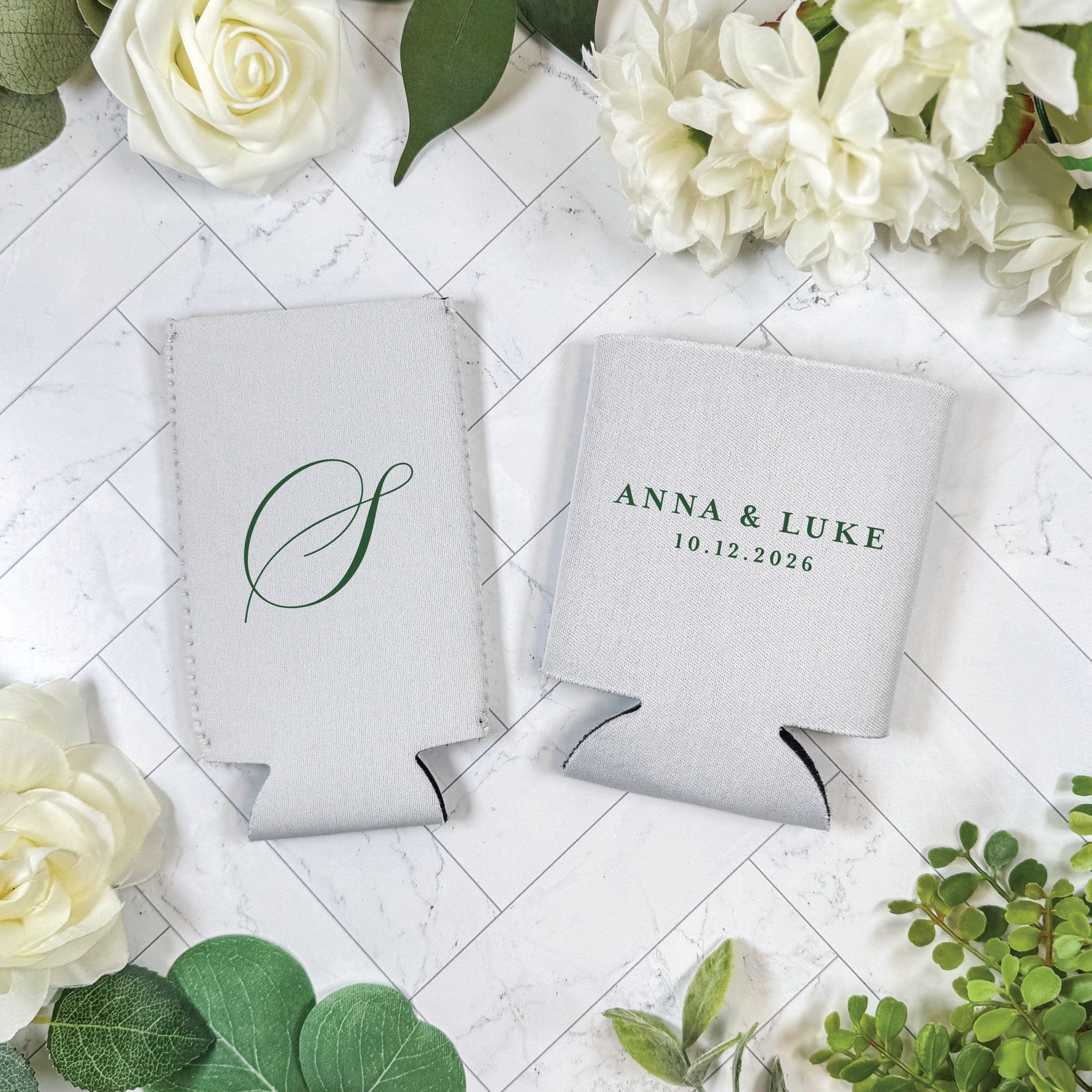 Two white insulating fabric can coolers are personalized with green text and a monogram, perfect for a wedding or special event.
