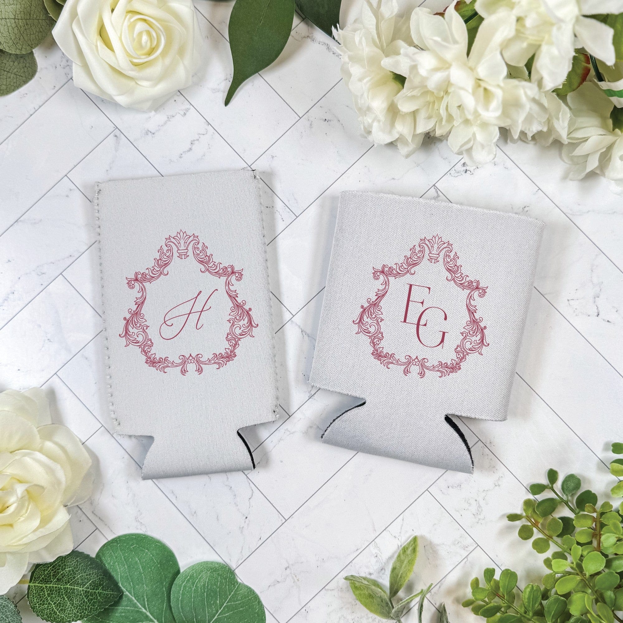 Two white neoprene can coolers featuring a red ornate frame design, ideal for keeping drinks cold at a wedding or special event.
